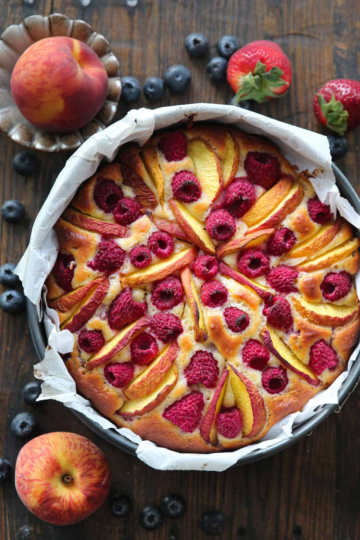 raspberry peach cake in a parchment paper-lined springform baking pan.