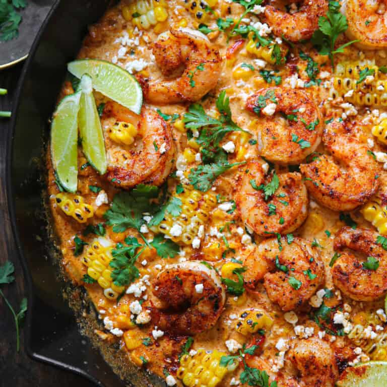 Shrimp and Creamed Corn (topped with crumbled feta cheese, lime slices, and chopped cilantro) - in a cast iron skillet.