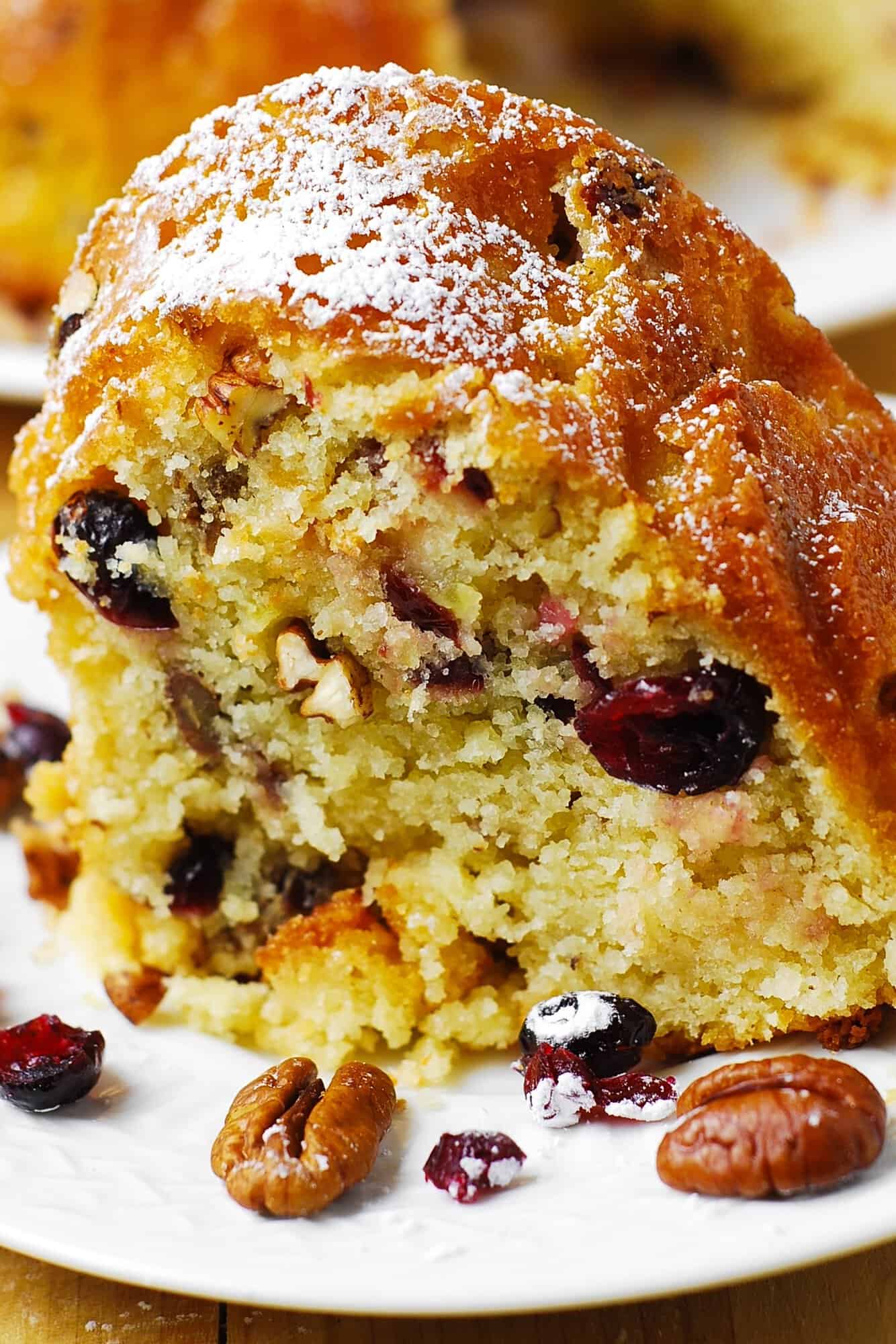 a slice of Cranberry Apple Pecan Bundt Cake - on a plate.