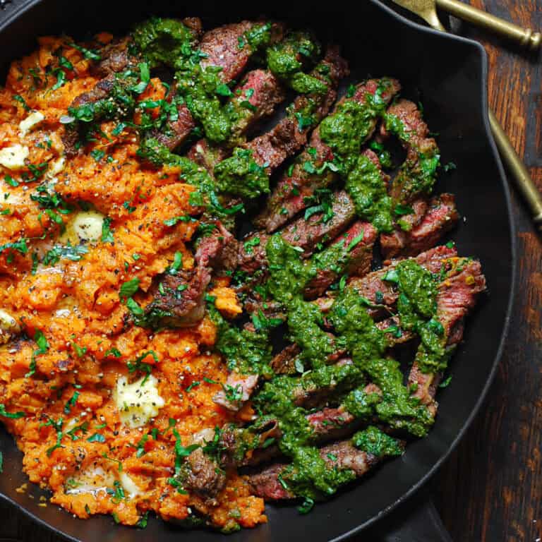 pan-seared flank steak (thinly sliced) with green spinach sauce and mashed sweet potatoes - in a cast iron skillet.