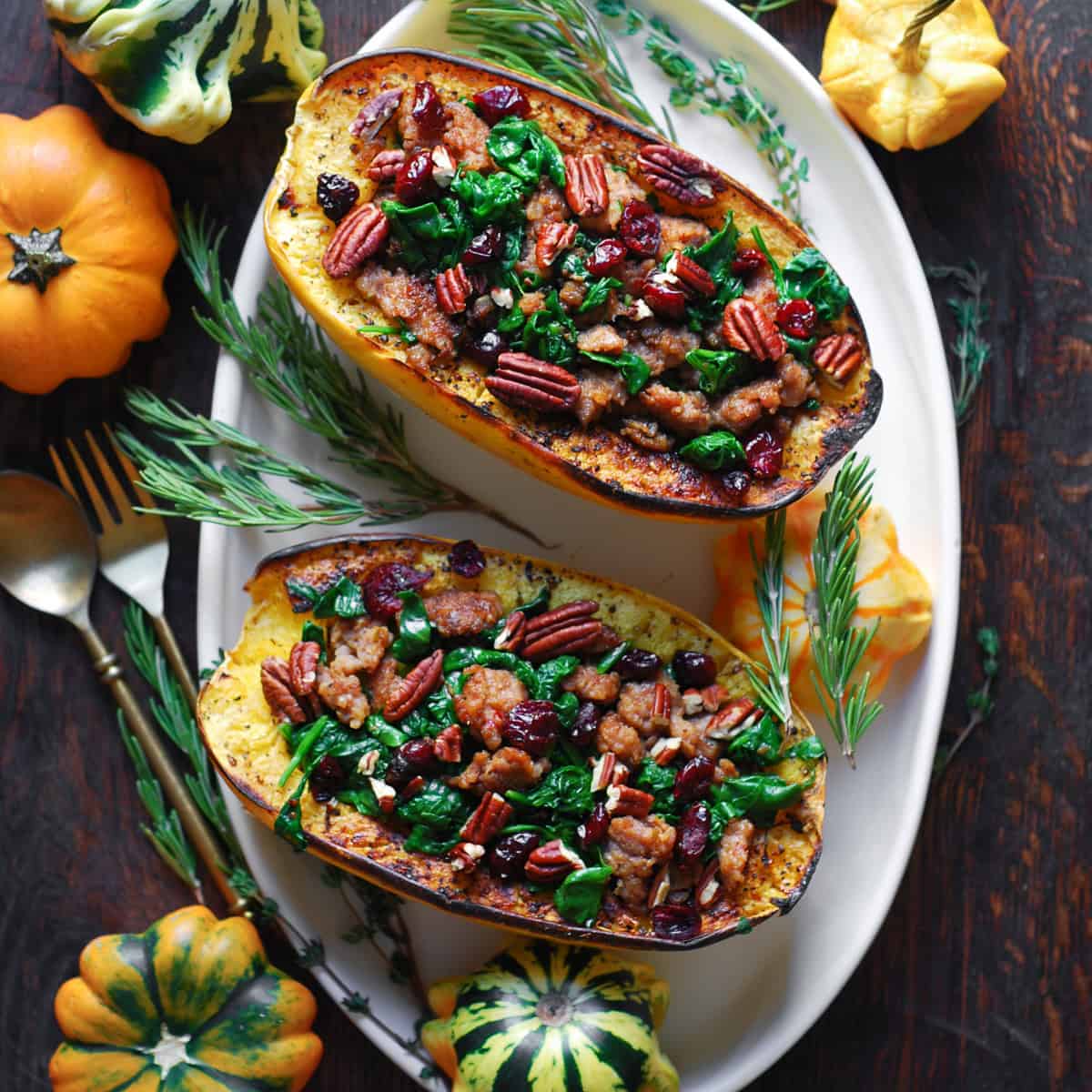 Stuffed Spaghetti Squash with Sausage, Spinach, Cranberries, and Pecans - on a white platter.