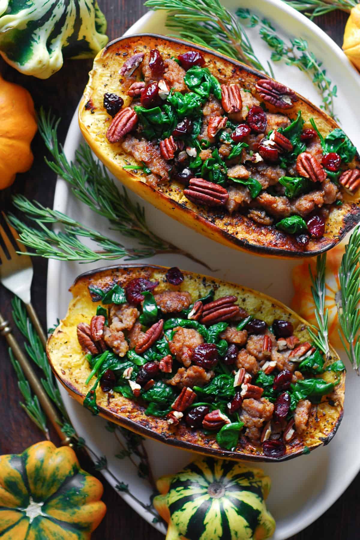 Stuffed Spaghetti Squash with Sausage, Spinach, Cranberries, and Pecans - on a white platter.