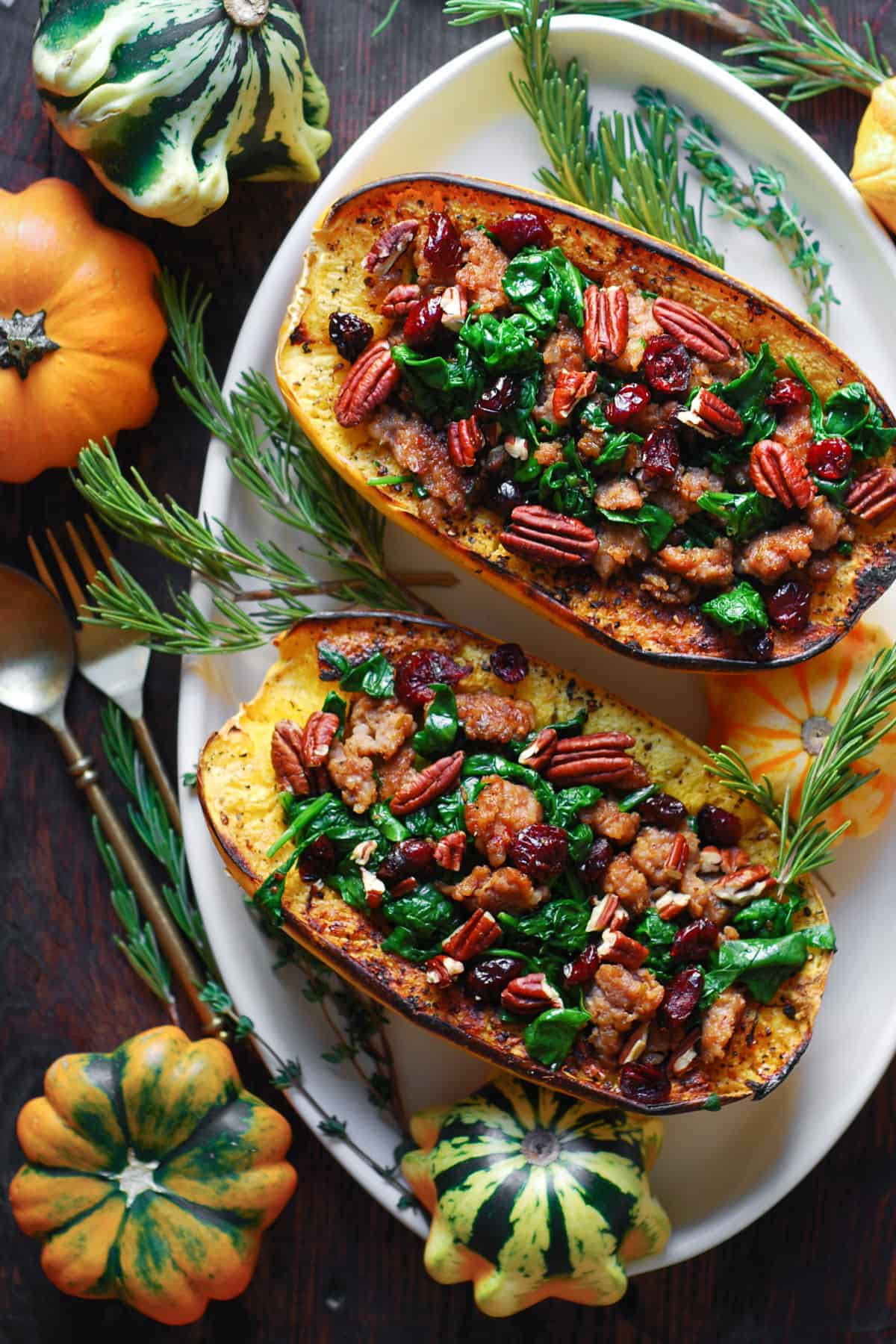 Stuffed Spaghetti Squash with Sausage, Spinach, Cranberries, and Pecans - on a white platter.