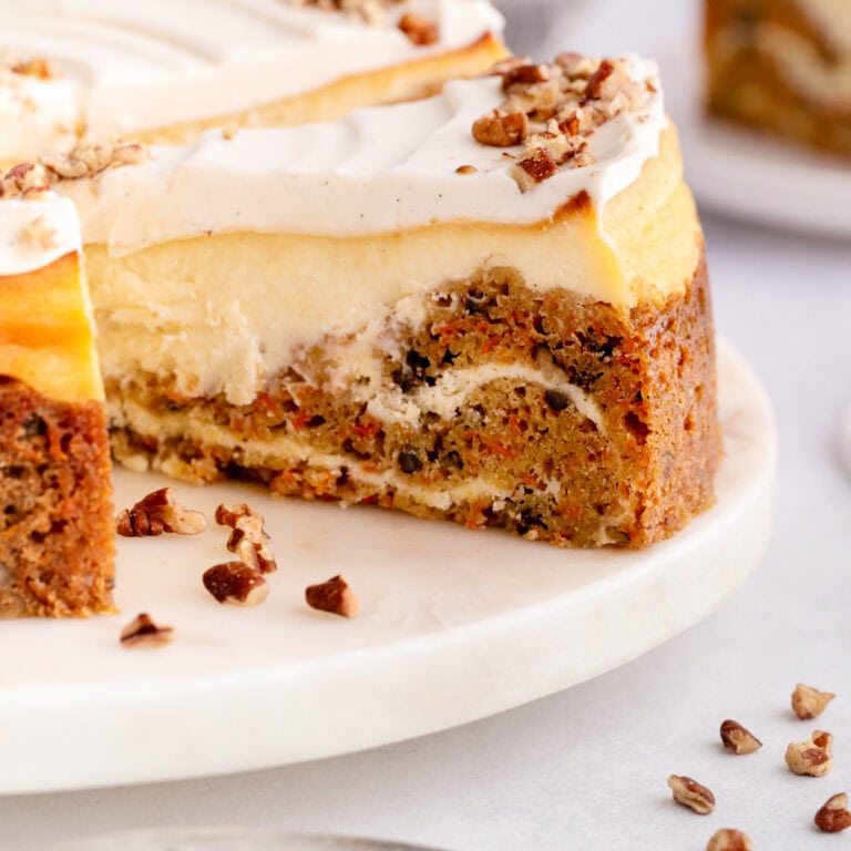 A slice of Carrot Cake Cheesecake on a platter.
