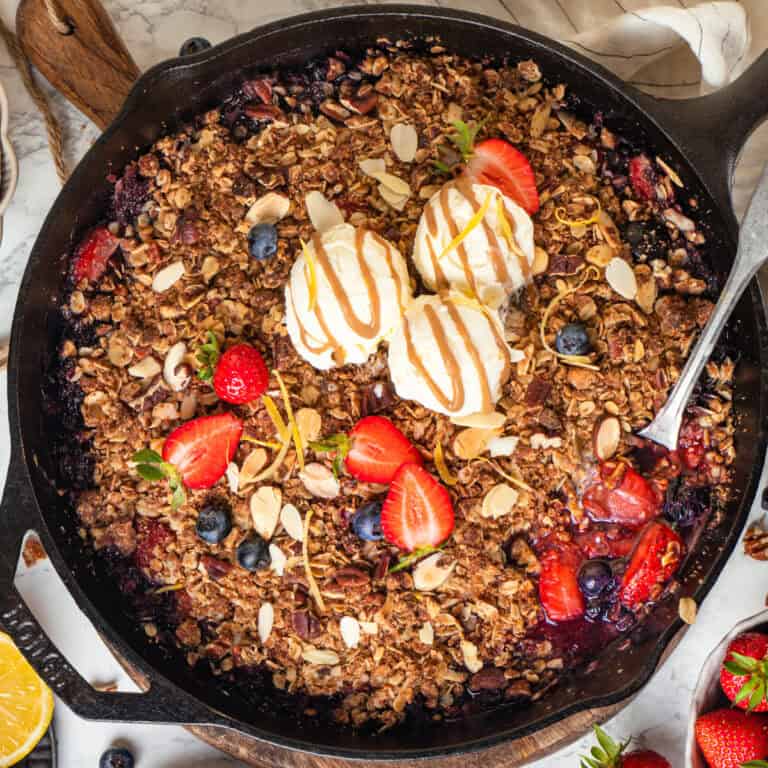 Strawberry Blueberry Crisp (with oats, cinnamon, almonds, and pecans topping) with 3 scoops of ice cream - in a cast iron skillet.