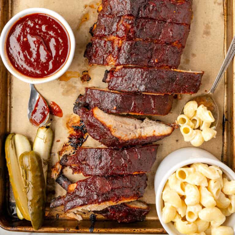 Oven-baked ribs with BBQ sauce on a sheet pan.
