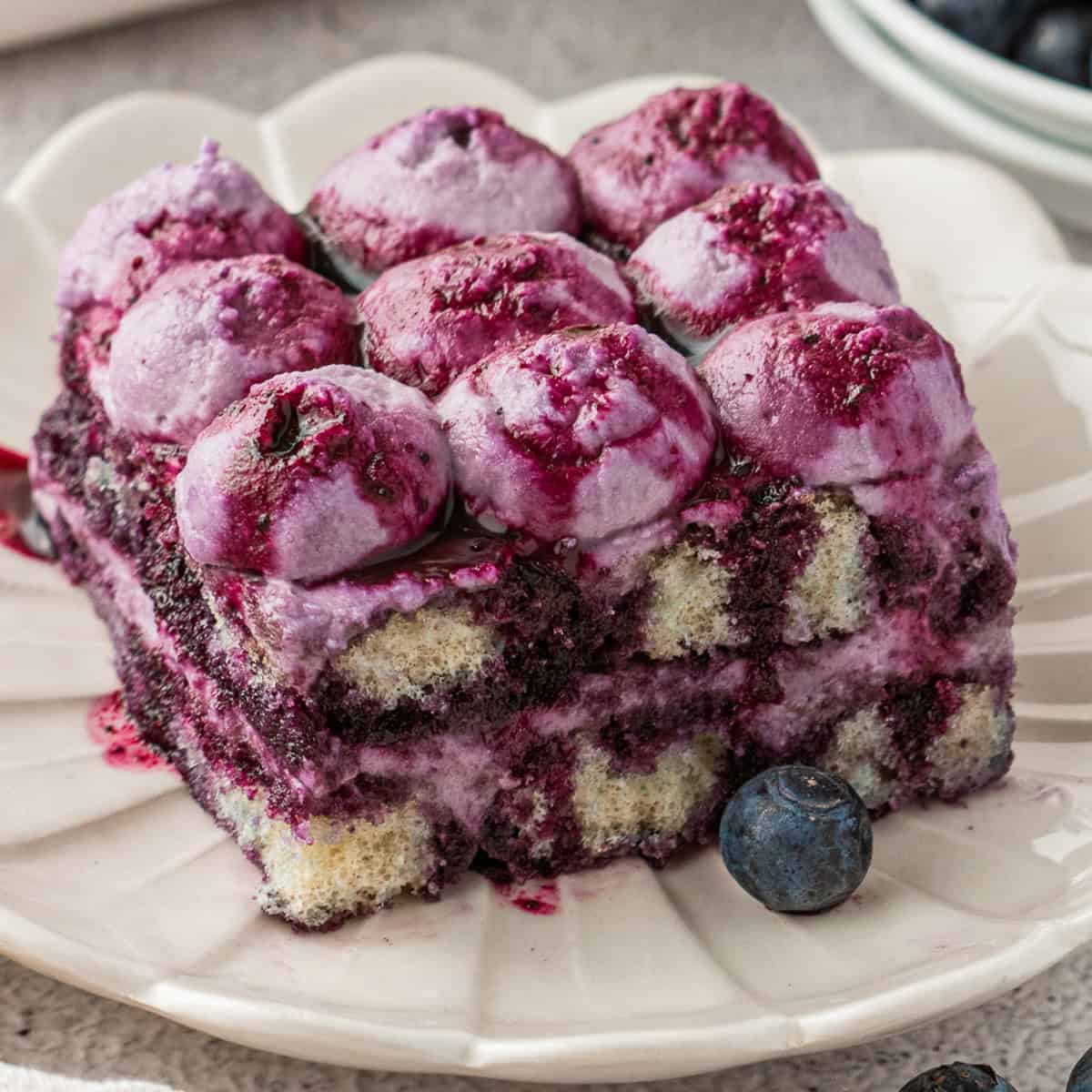 Blueberry Tiramisu A slice of Blueberry Tiramisu on a white plate.