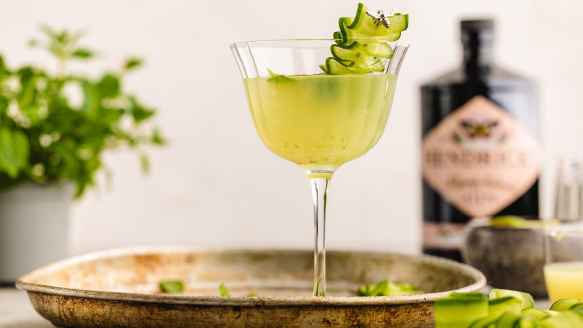 Meet your new go-to summer cocktail: the Cucumber Gimlet! Cucumber Gimlet Cocktail in a glass garnished with a cucumber ribbon.