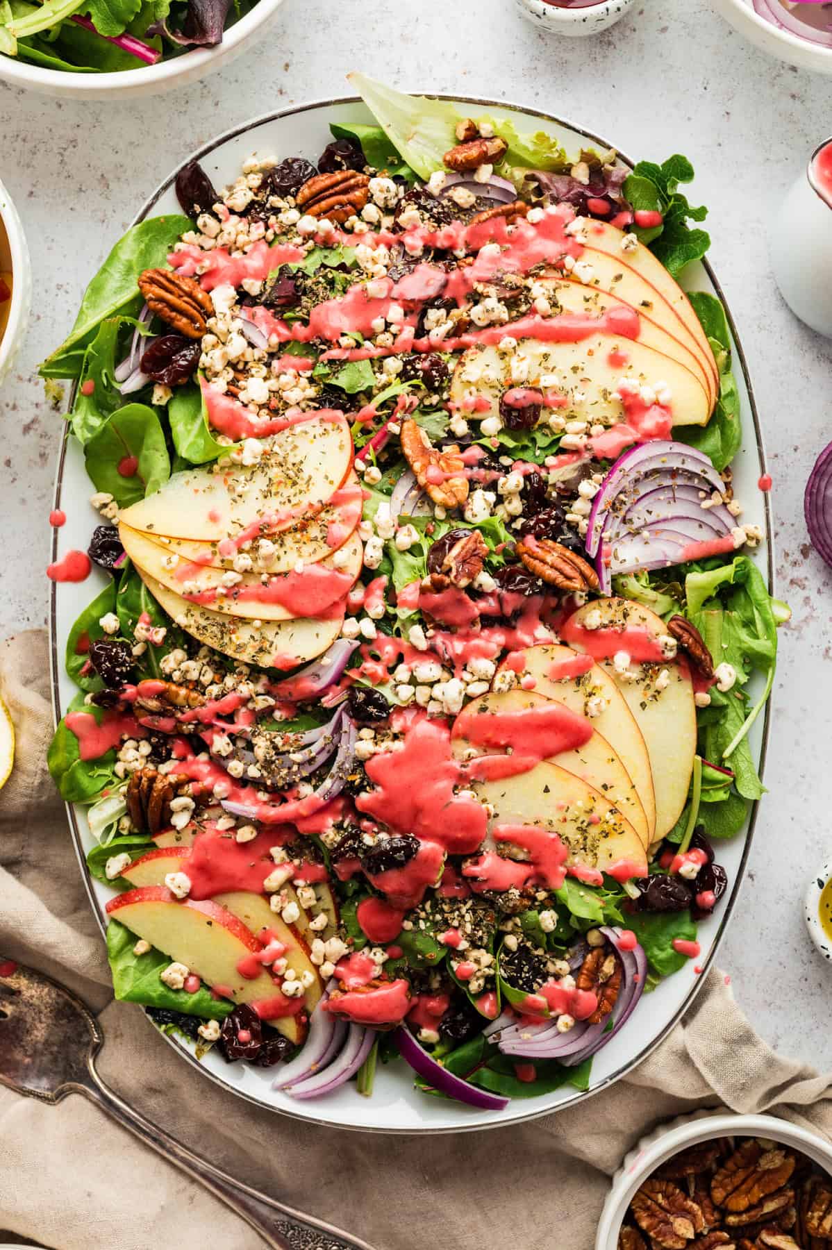 Simple Green Salad with Apples and Raspberry Vinaigrette Simple Green Salad with Apples, Dried Cherries, Goat Cheese, Pecans, and Raspberry Vinaigrette - on a large white platter.