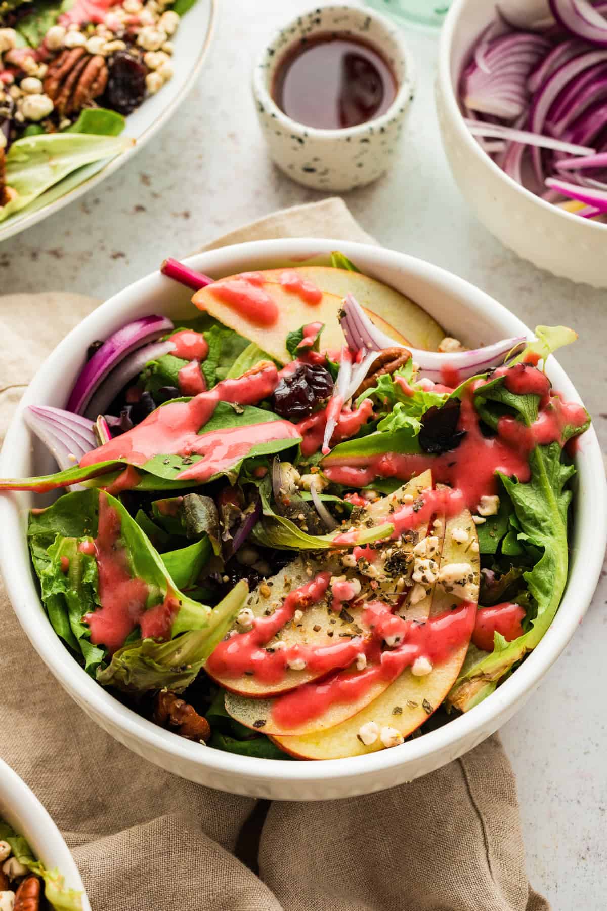 Simple Green Salad with Apples and Raspberry Vinaigrette - in a small white bowl.