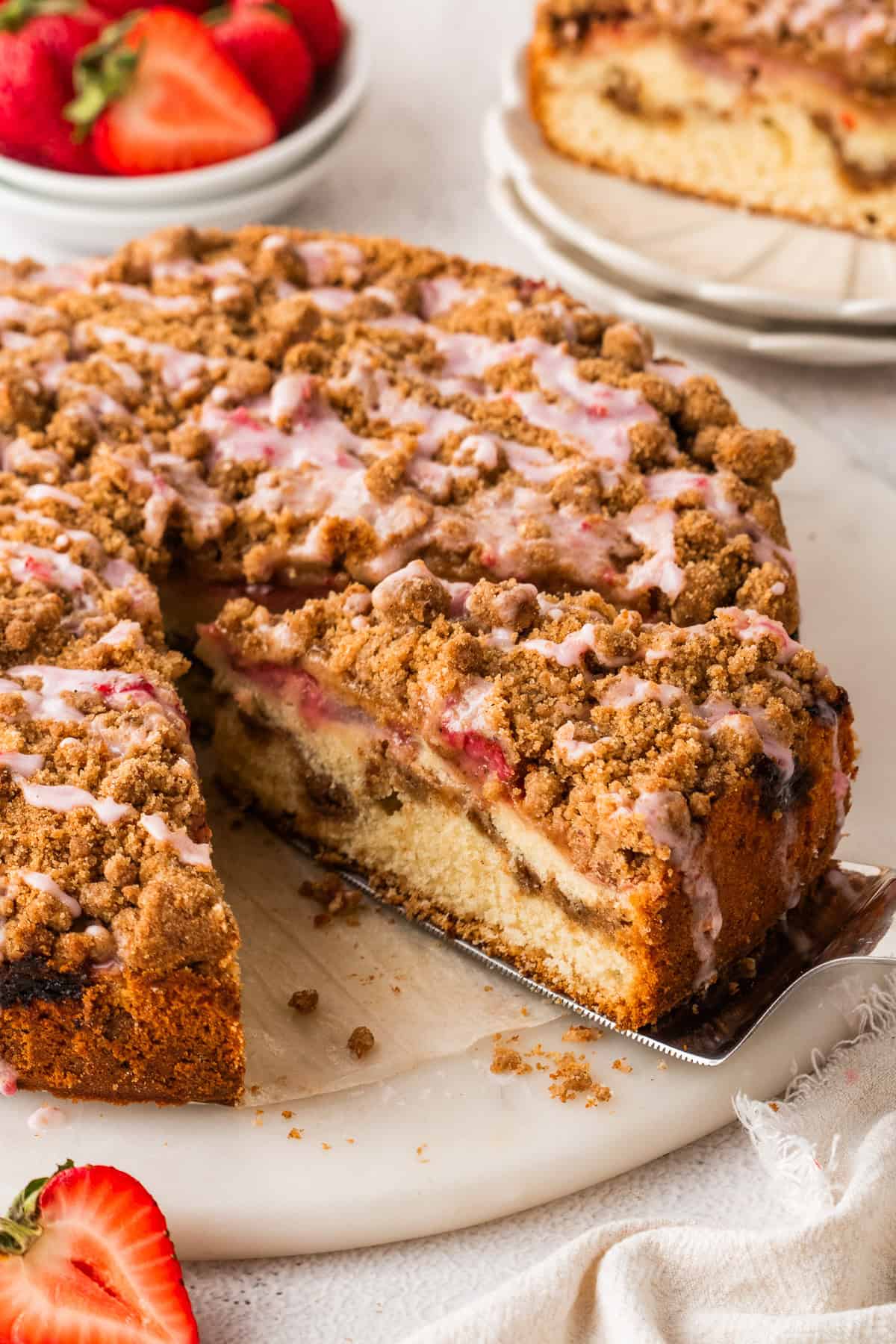 Strawberry Coffee Cake topped with streusel and pink strawberry glaze.