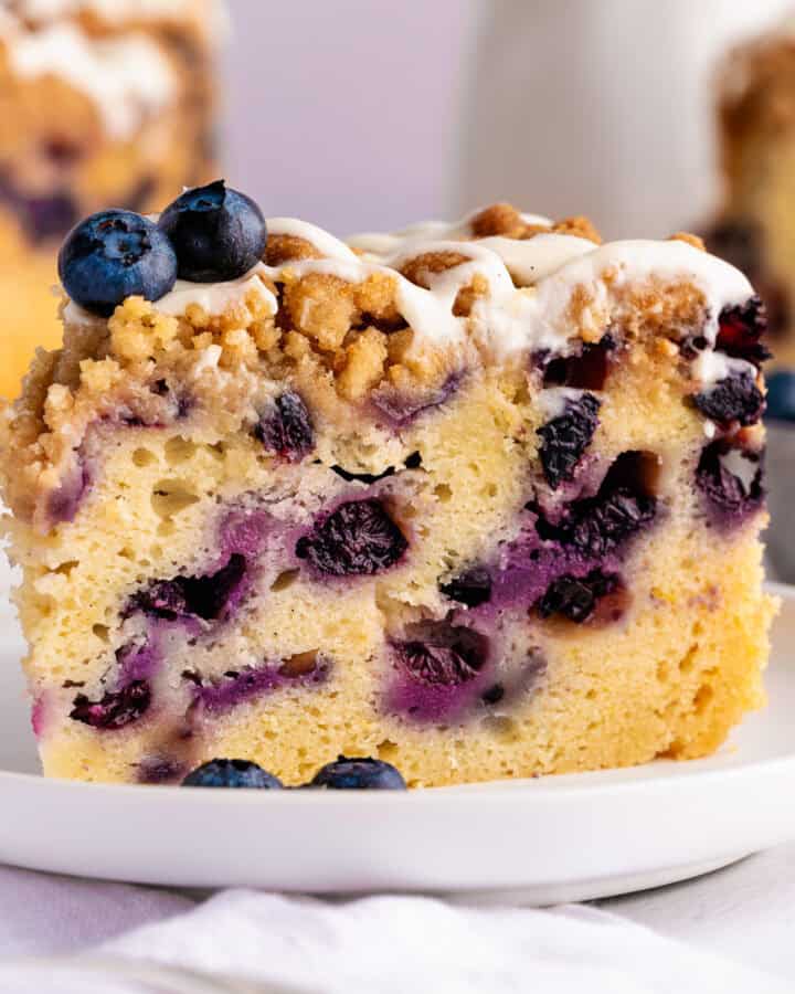 A slice of Blueberry Coffee Cake with Streusel Crumb Topping on a white plate.