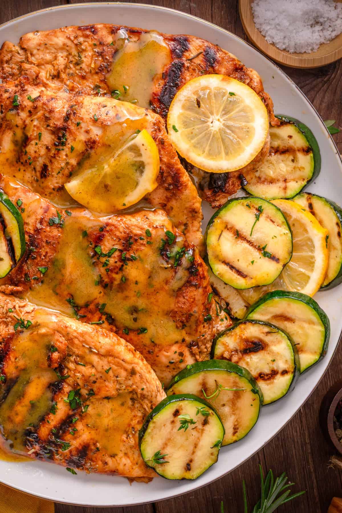 Grilled Chicken Breasts Grilled Chicken Breasts with grilled zucchini rounds on a white plate.