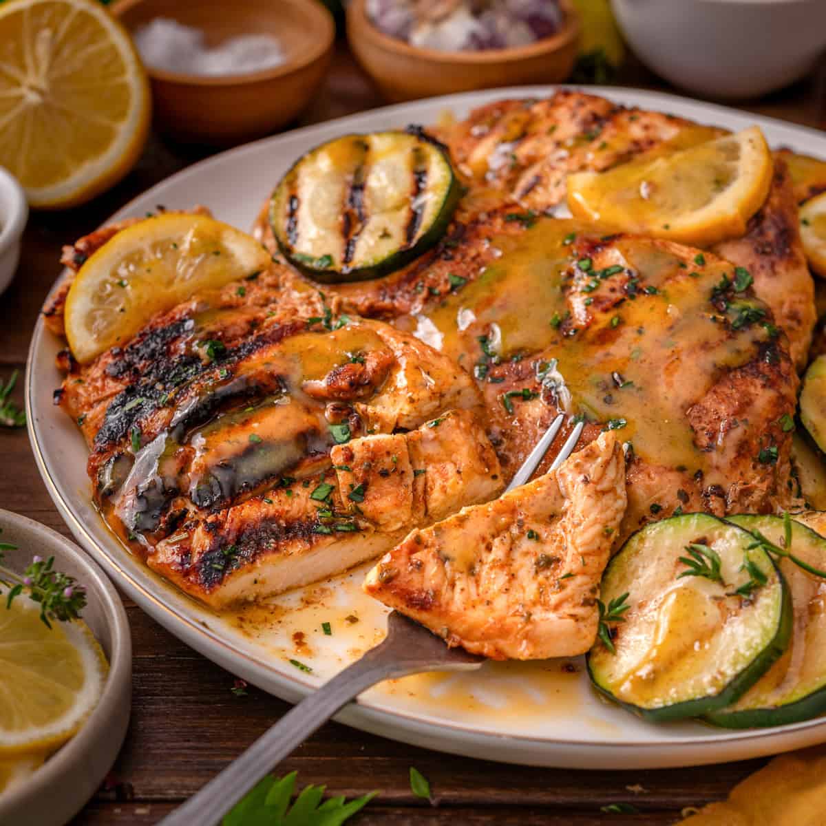 Grilled Chicken Breasts Grilled Chicken Breasts with grilled zucchini rounds on a white plate.