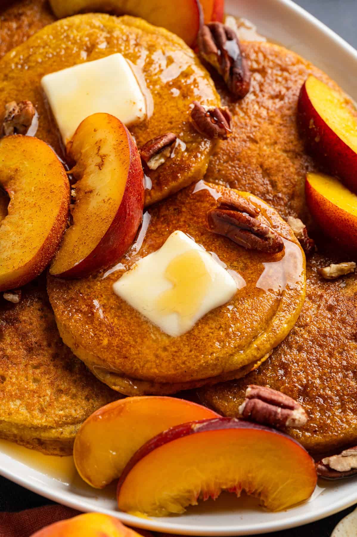 Peach Pancakes with Cinnamon Maple Syrup and Pecans Peach Pancakes with Cinnamon Maple Syrup, Butter, Peach Slices, and Pecans.