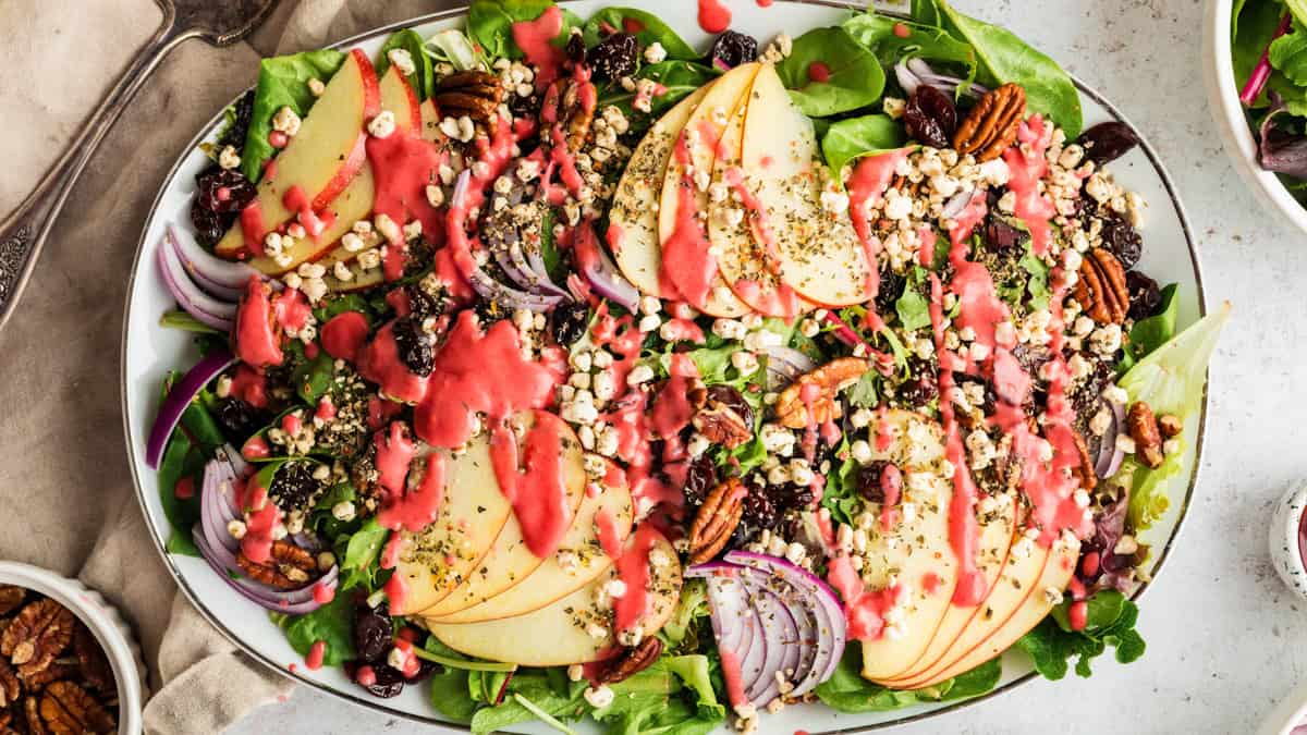 Simple Green Salad with Apples, Dried Cherries, Goat Cheese, Pecans, and Raspberry Vinaigrette Simple Green Salad with Apples, Dried Cherries, Goat Cheese, Pecans, and Raspberry Vinaigrette - on a large white platter.