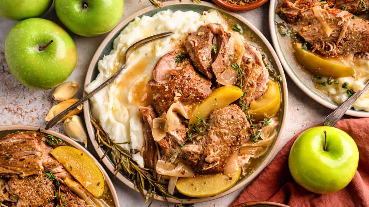 Apple Cider Braised Pork Shoulder with Sliced Apples and mashed potatoes - on a plate.