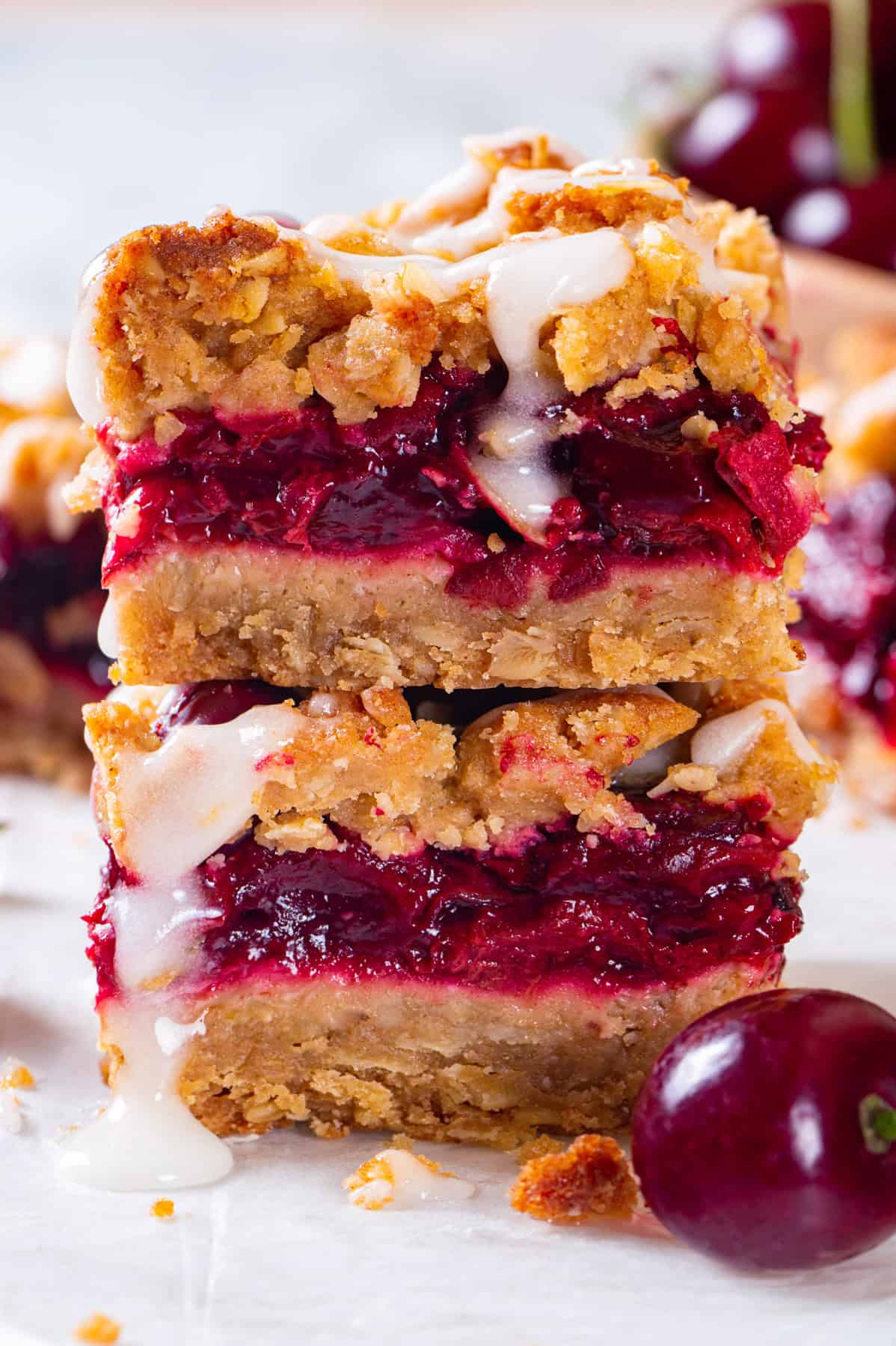 Cherry Pie Bars Cherry Pie Bars with Oat Crust and Lemon Glaze (2 bars stacked on each other).