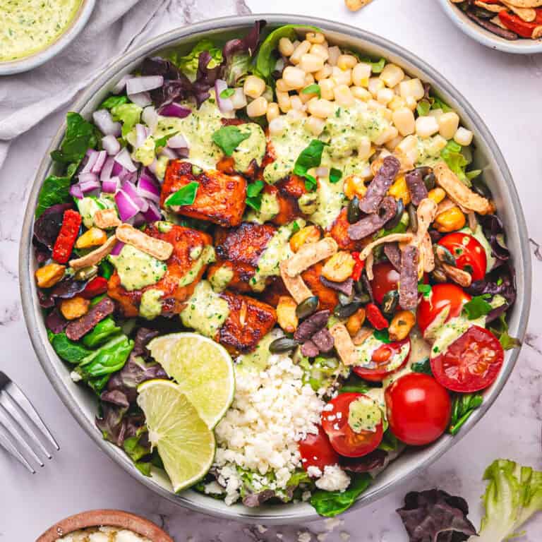 Summer Salmon Salad Bowl with Corn, Cherry Tomatoes, Cotija, Lime Wedges and Smoky Poblano Ranch Dressing.