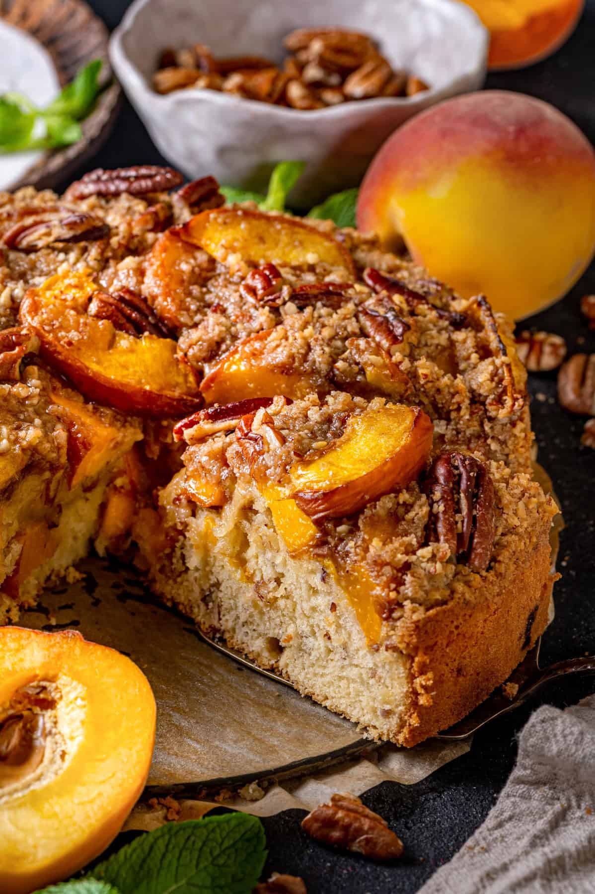 Peach Coffee Cake with Pecan Streusel Peach Coffee Cake with a slice cut out.