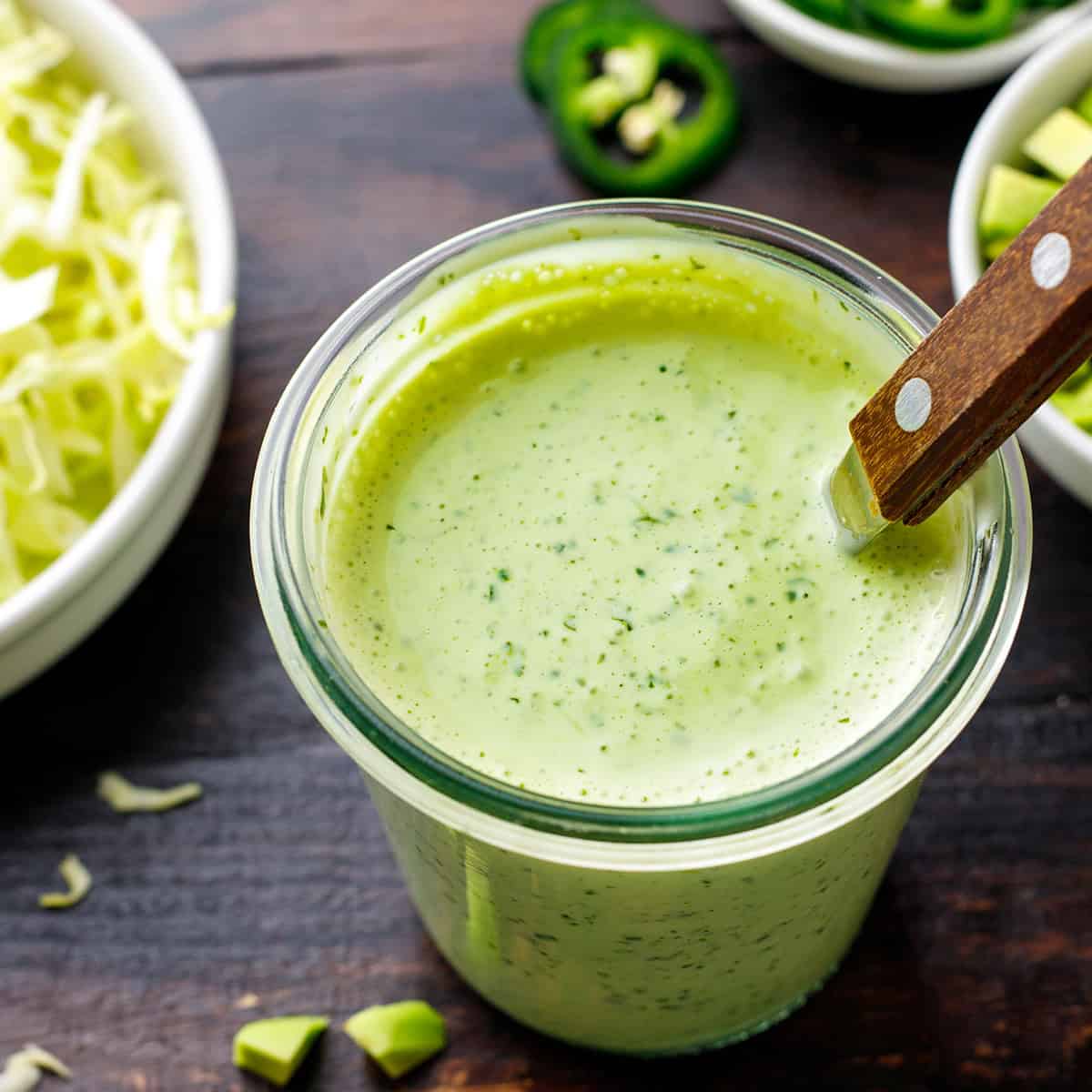 Shrimp Taco Sauce (Cilantro-Lime Crema) Creamy Cilantro Lime Sauce (light green color) in a small glass jar.