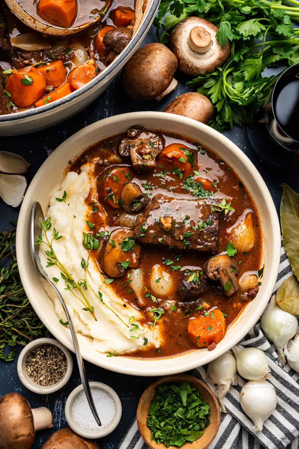Beef Bourguignon with mashed potatoes in a white bowl.