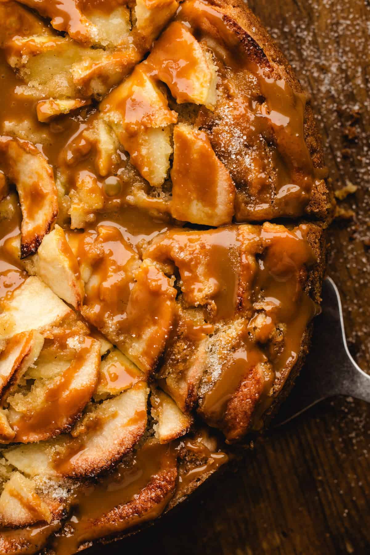 German Apple Cake drizzled with caramel sauce and sliced.