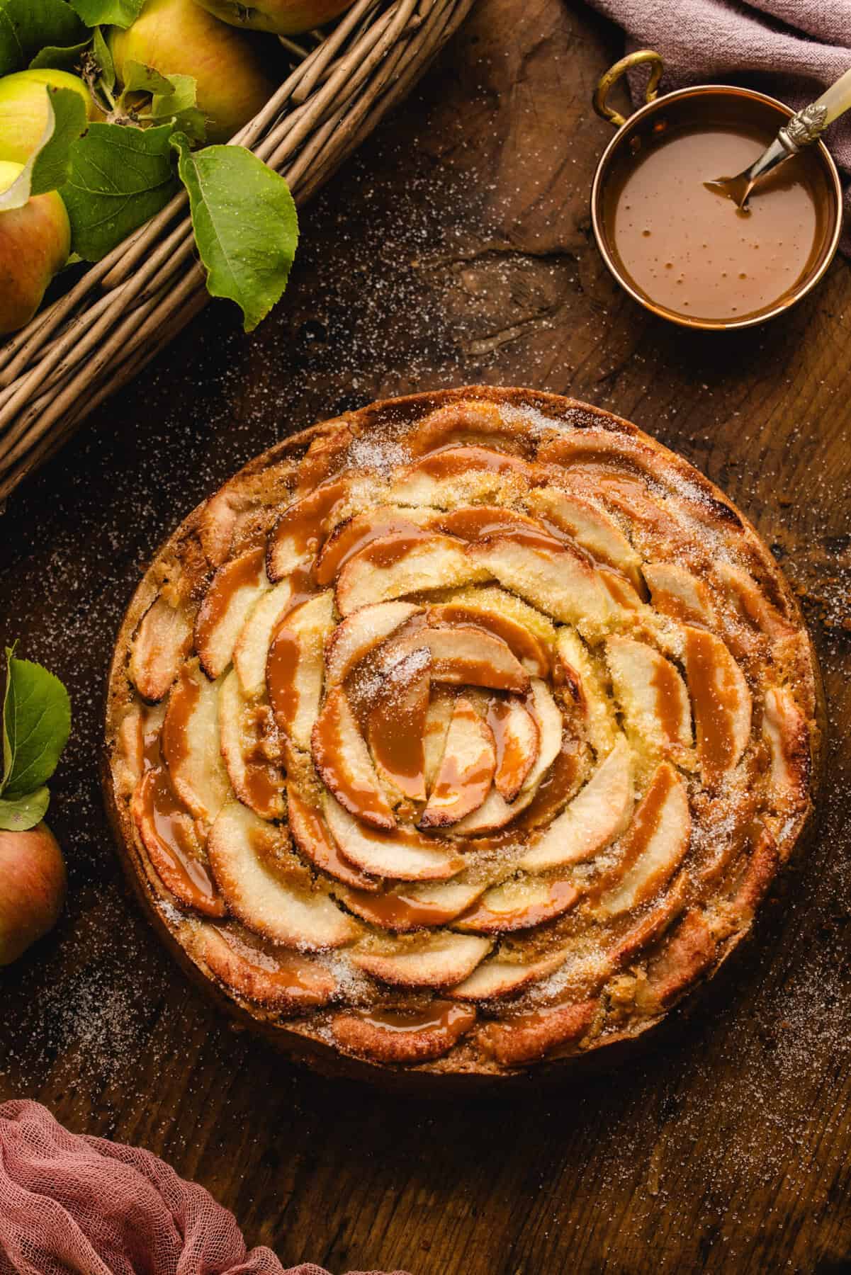 German Apple Cake drizzled with caramel sauce on a wooden background.