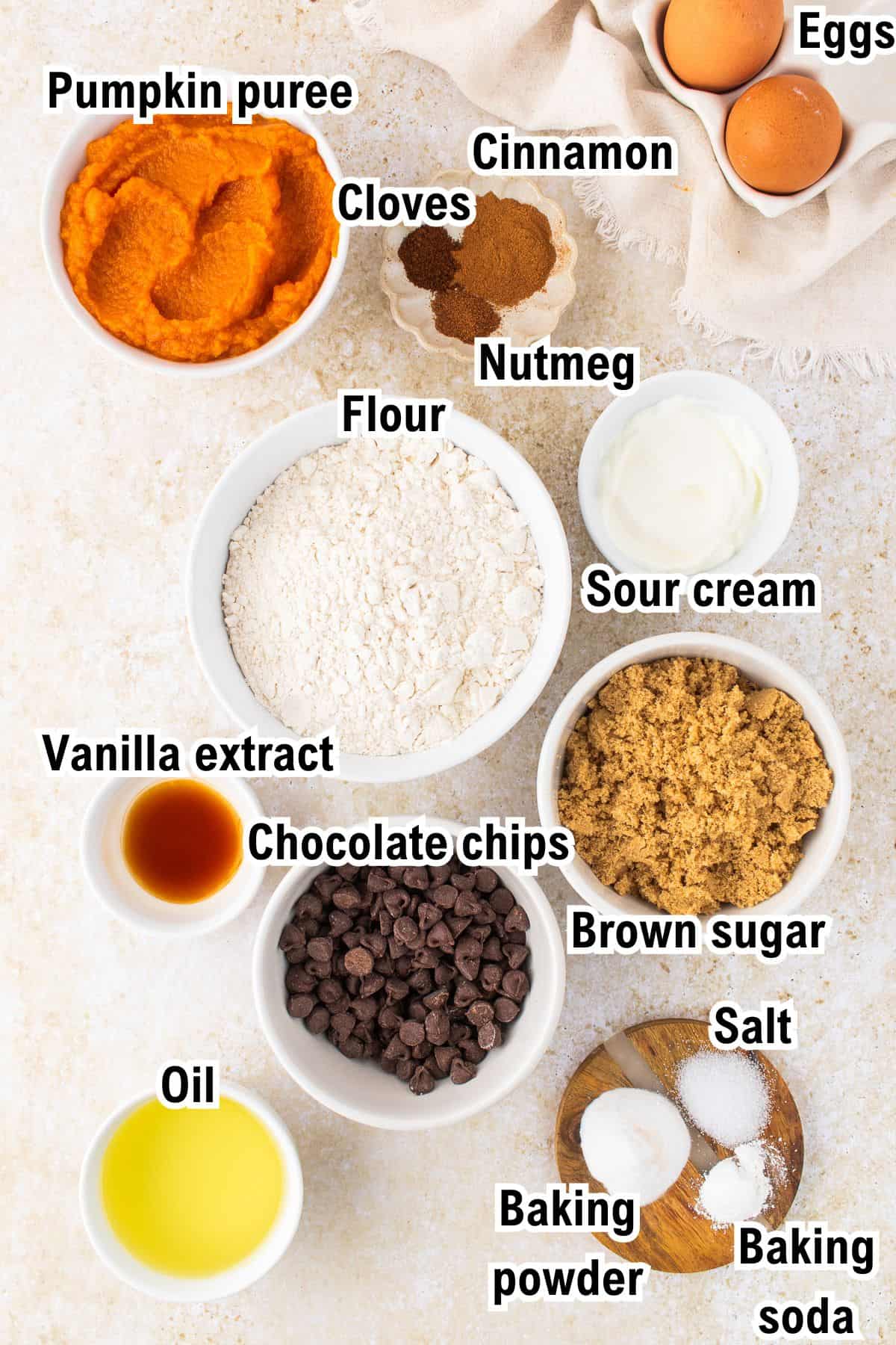 The Ingredients for Pumpkin Chocolate Chip Muffins This photo shows the ingredients for Pumpkin Chocolate Chip Muffins: Pumpkin puree, cloves, cinnamon, nutmeg, eggs, flour, sour cream, vanilla extract, chocolate chips, brown sugar, oil, salt, baking powder, and baking soda.