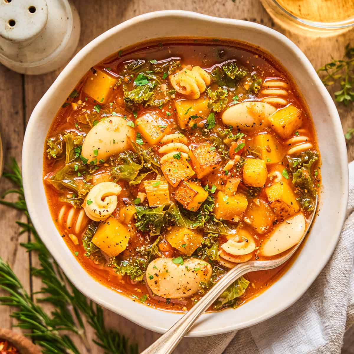Winter Minestrone Soup with Butternut Squash and Kale in a white bowl.
