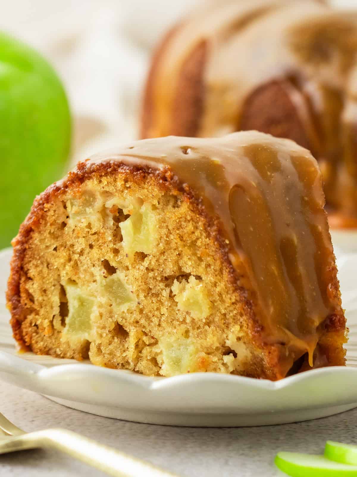 Apple Bundt Cake with Caramel Sauce A slice of Apple Bundt Cake with Caramel Sauce on a small white plate.