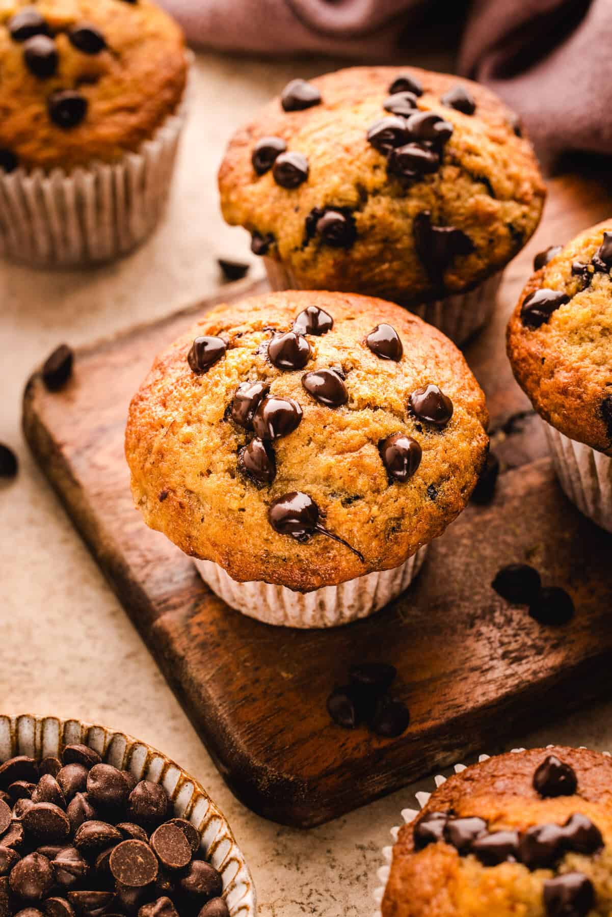Banana Chocolate Chip Muffins on a wooden cutting board.