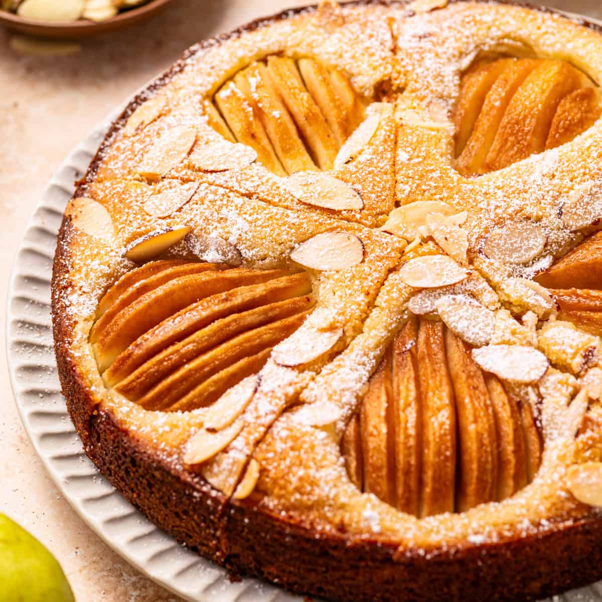 Pear Cake with Almond Flour, Almonds, and Fresh Pears - on a large plate.