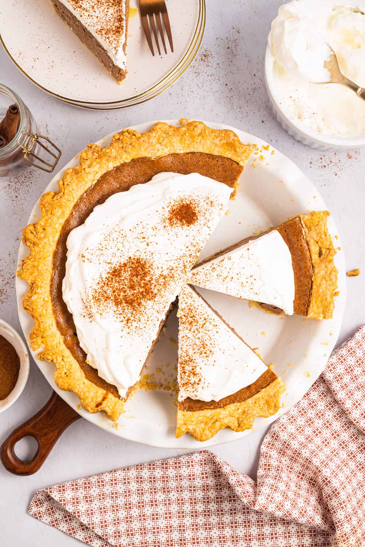 Cinnamon Pie Cinnamon Pie topped with whipped cream in a pie dish, cut into slices.