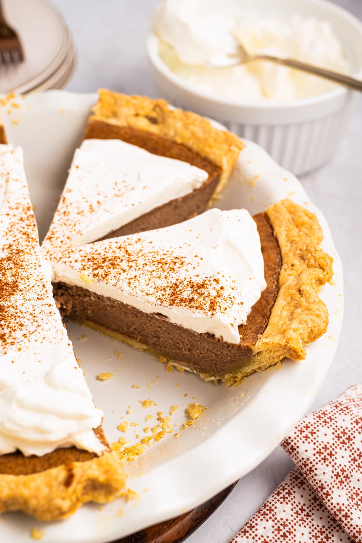 Cinnamon Pie Two slices of Cinnamon Pie topped with whipped cream - in a pie dish.