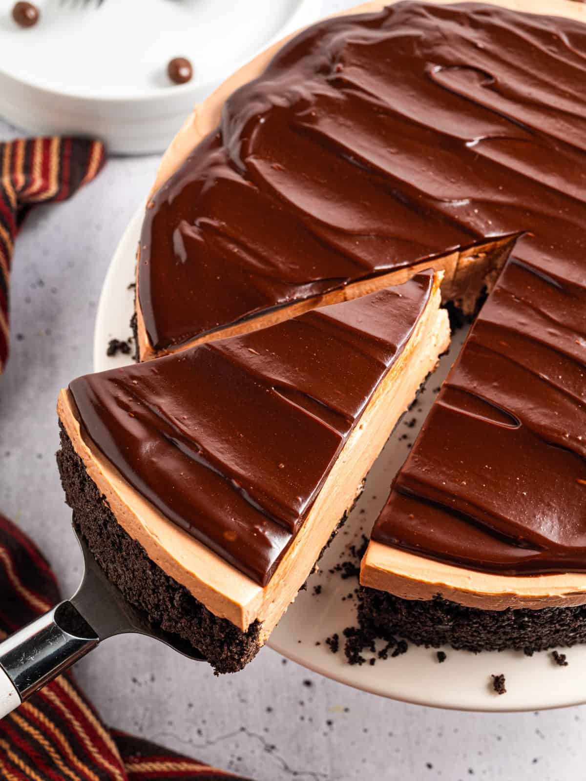 A slice of Mocha Cheesecake on a spatula sliding out of the cake.