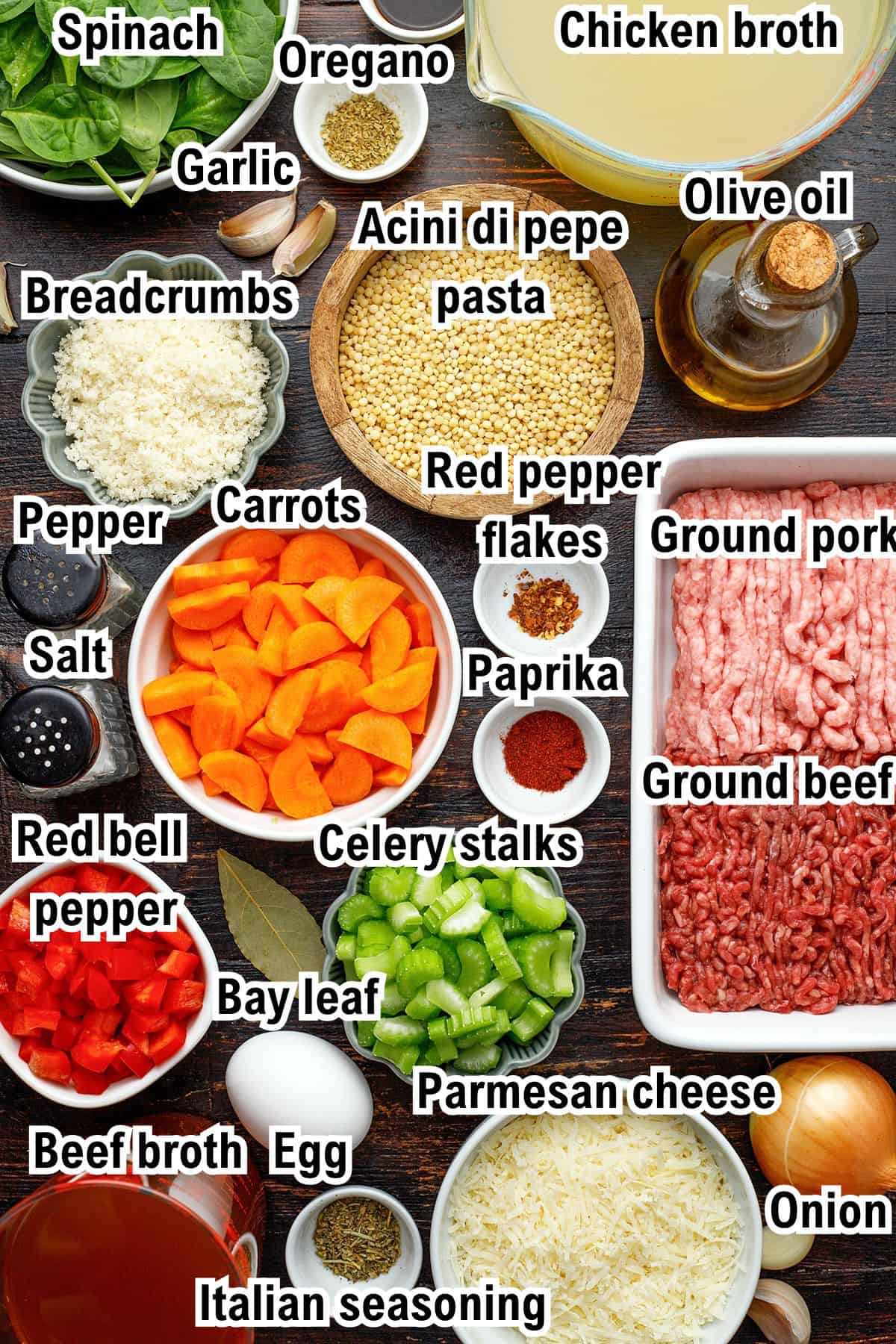 The Ingredients for Italian Wedding Soup Various labeled ingredients for Italian wedding soup are arranged on a table, including ground pork, ground beef, pasta, vegetables, spices, broths, parmesan cheese, breadcrumbs, and olive oil.