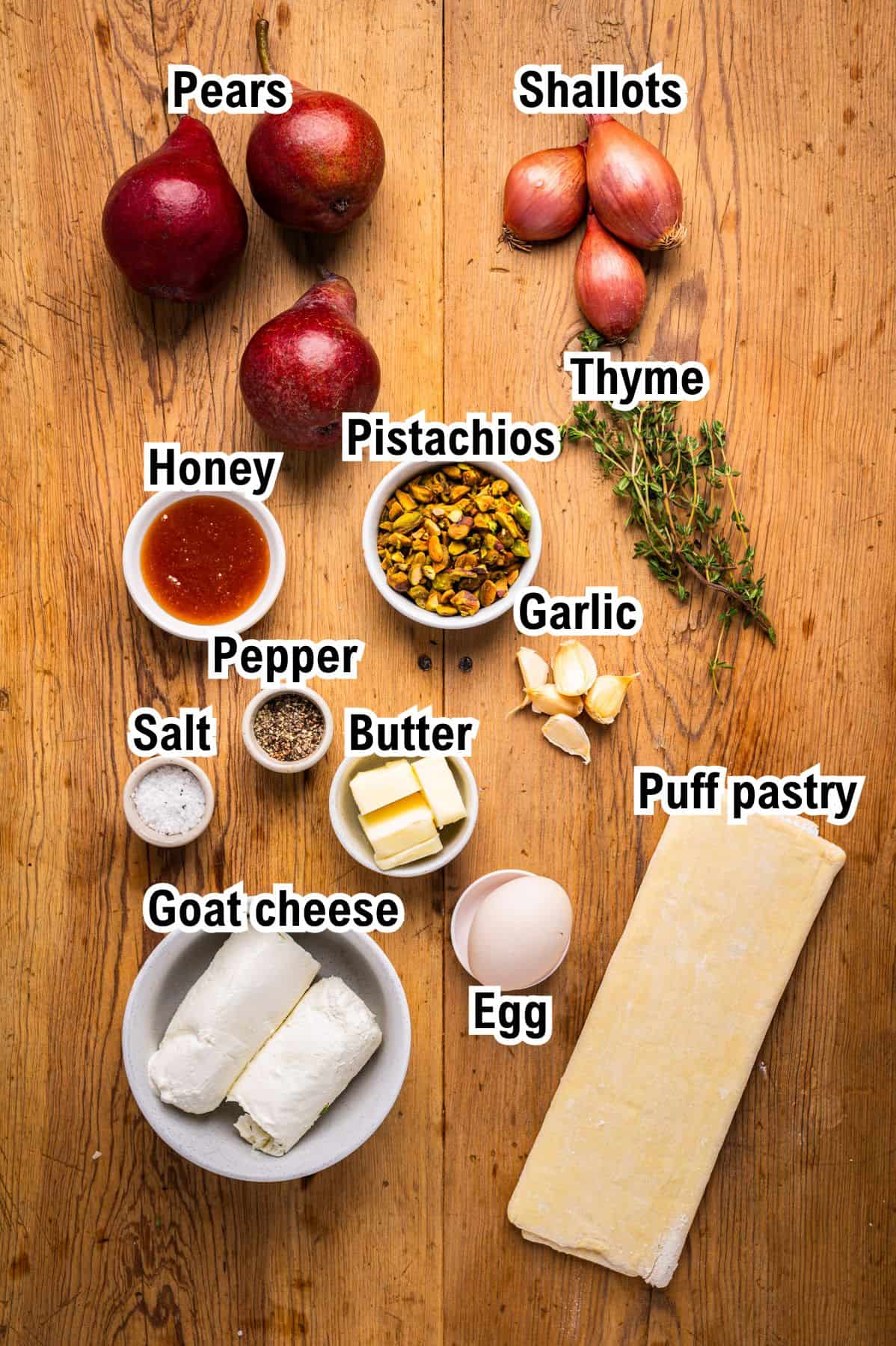 The Ingredients for Pear Tart This photo shows the ingredients for Pear Tart: pears, shallots, thyme, pistachios, honey, garlic, pepper, salt, butter, puff pastry, goat cheese, and an egg, each labeled with text.