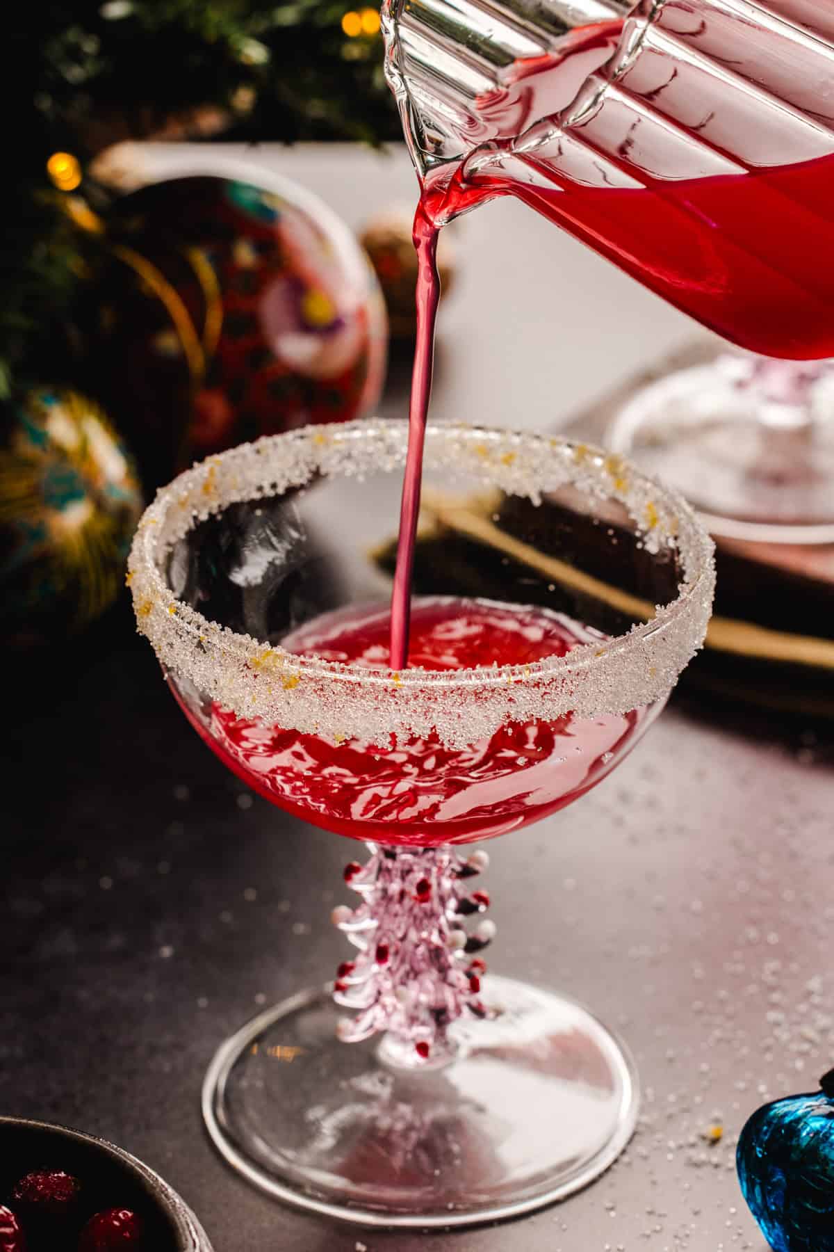 Pouring cranberry juice into a glass.