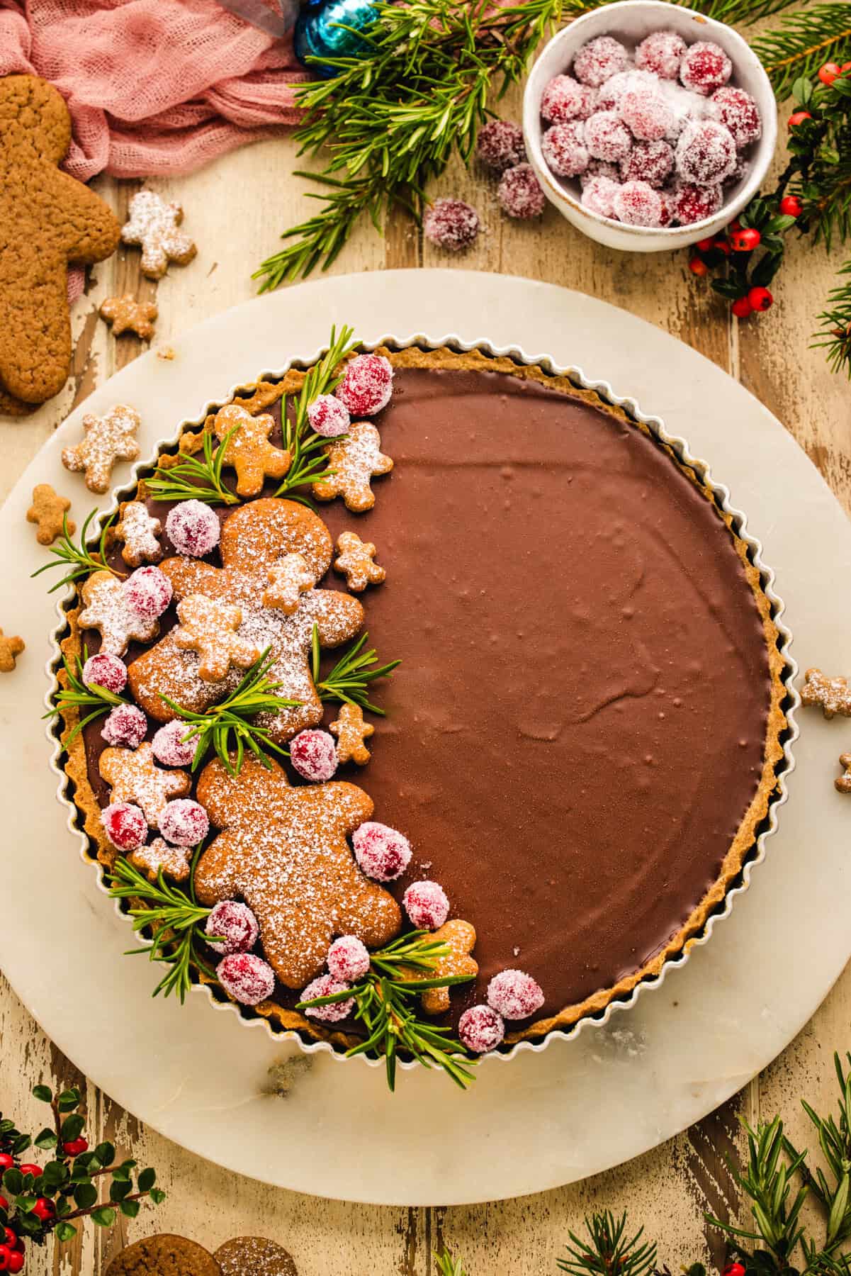 Gingerbread Cookie Chocolate Tart (decorated with gingerbread men cookies and sugared cranberries on one side).