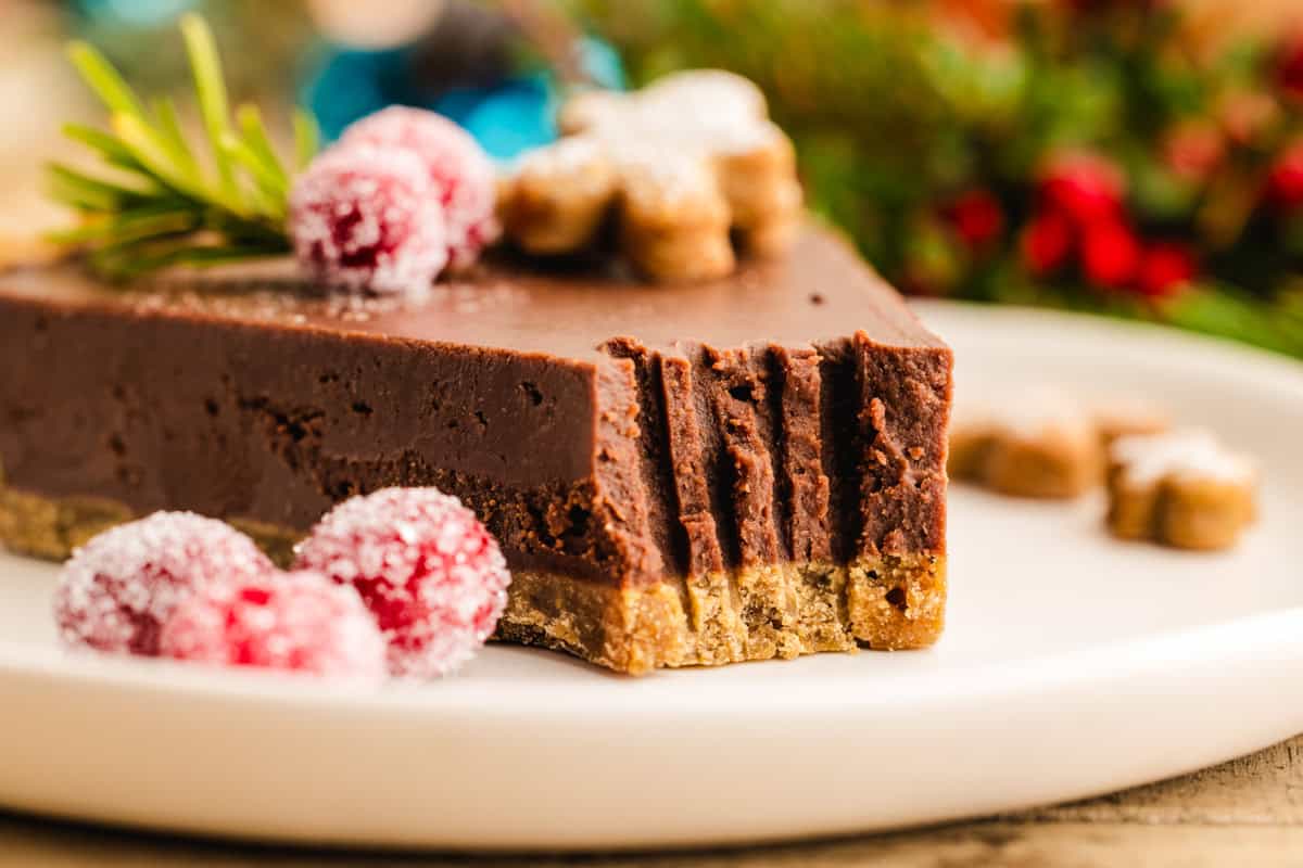 Slice of Gingerbread Chocolate Tart with a fork bite taken out - on a plate.