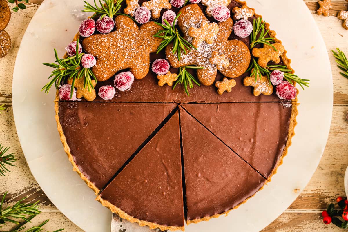 Gingerbread Cookie Chocolate Tart (decorated with gingerbread men cookies and sugared cranberries on one side).