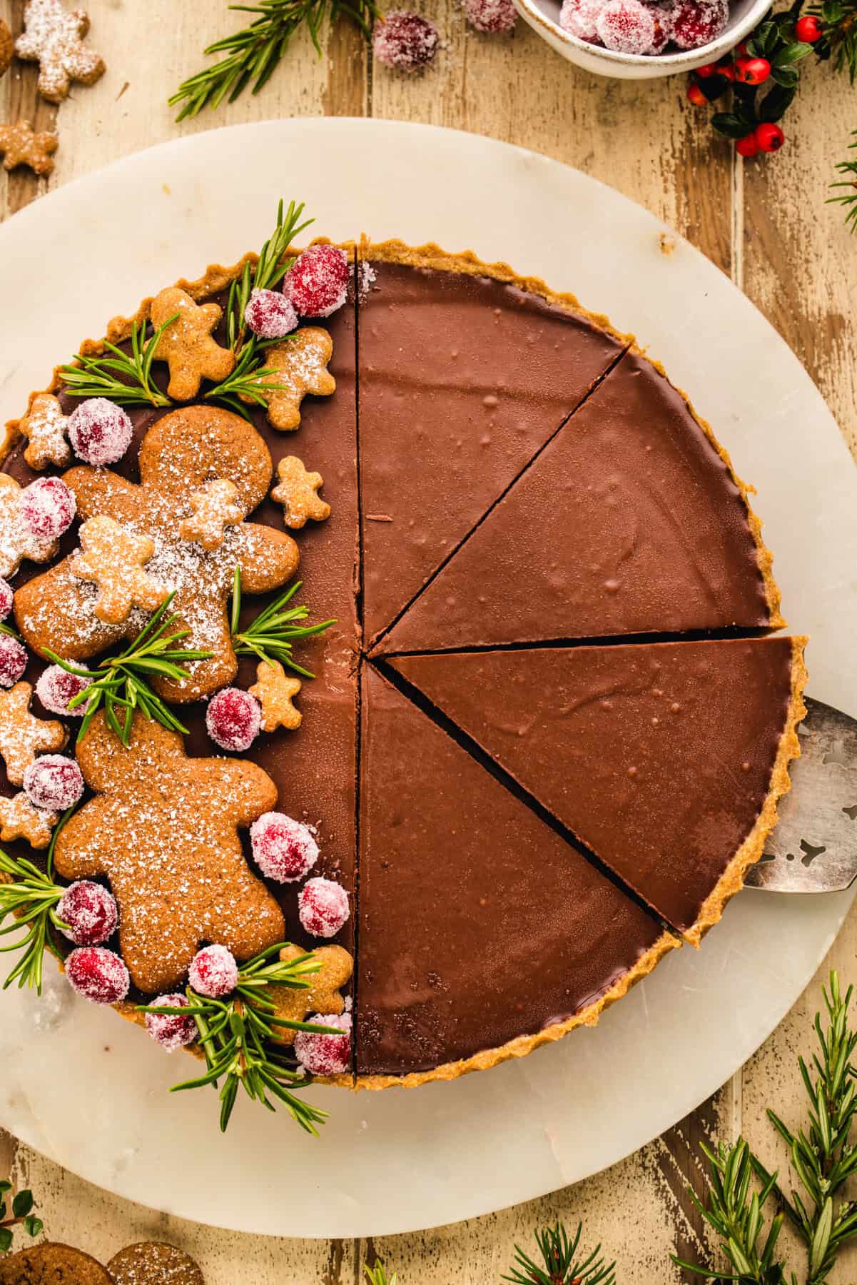 Gingerbread Cookie Chocolate Tart (decorated with gingerbread men cookies and sugared cranberries on one side).