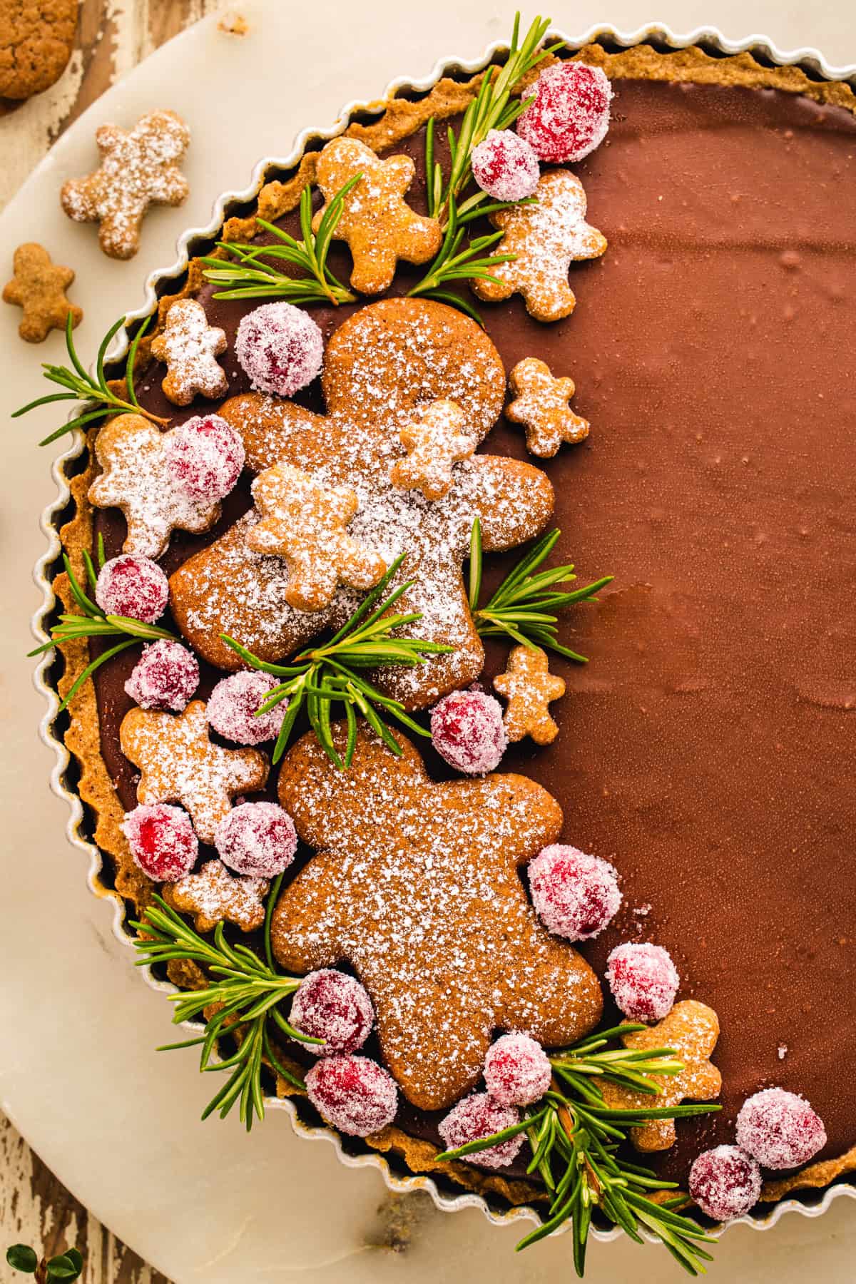 Gingerbread Cookie Chocolate Tart (decorated with gingerbread men cookies and sugared cranberries on one side).