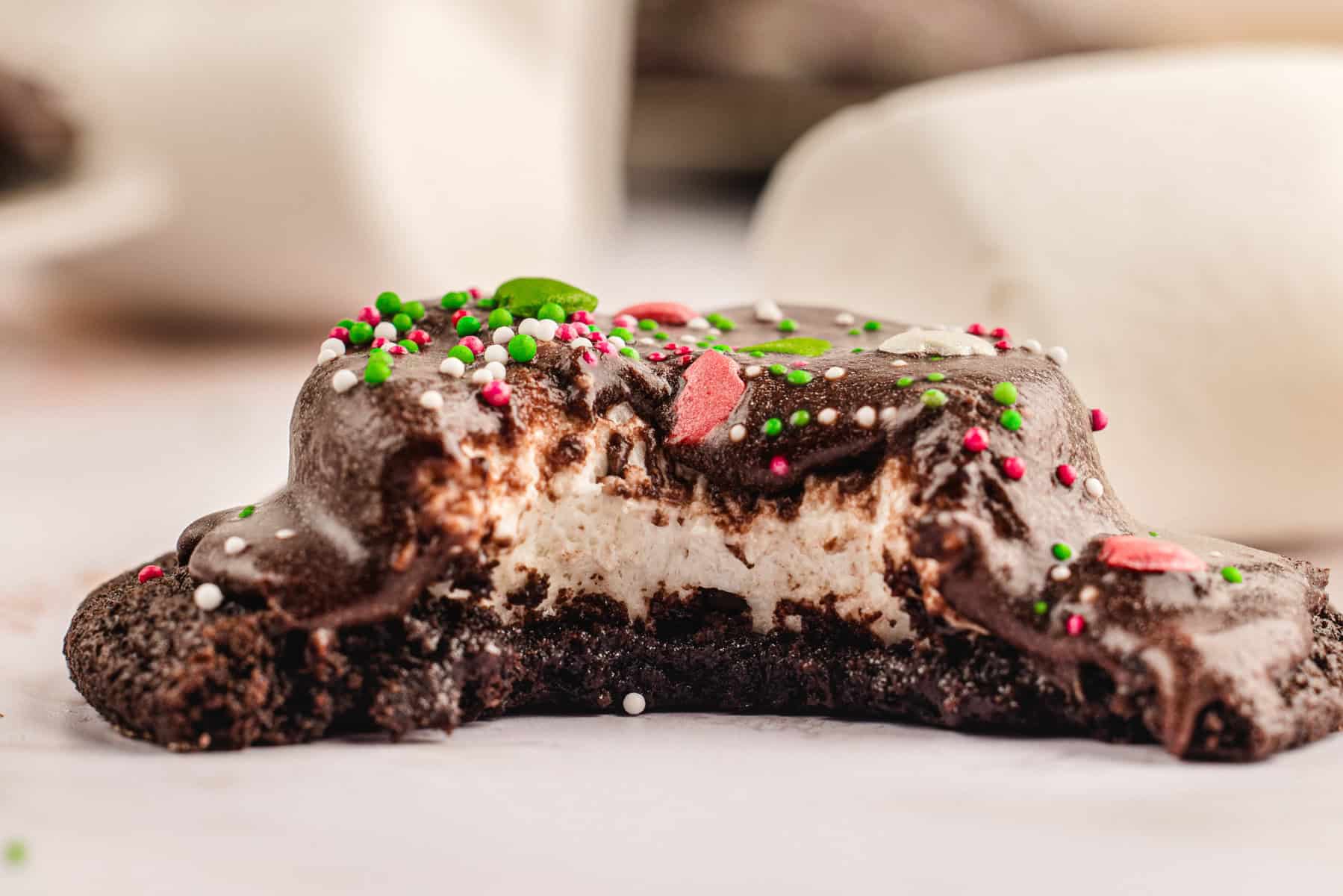 Hot Cocoa Cookies Hot Cocoa Cookies (with a bite out, revelaing a marshmallow inside).