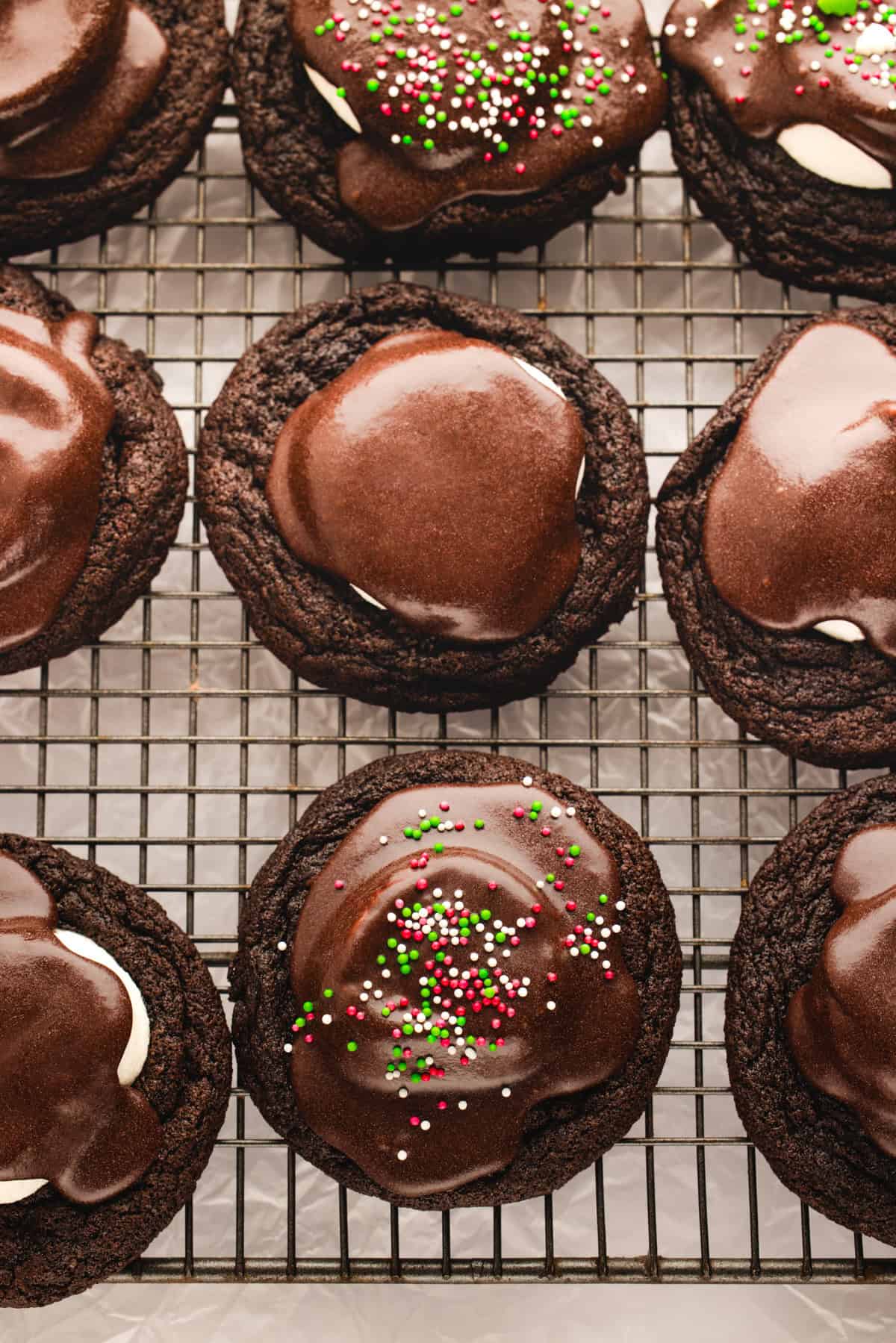Hot Cocoa Cookies Hot Cocoa Cookies (some topped with sprinkles some without) - on a rack.