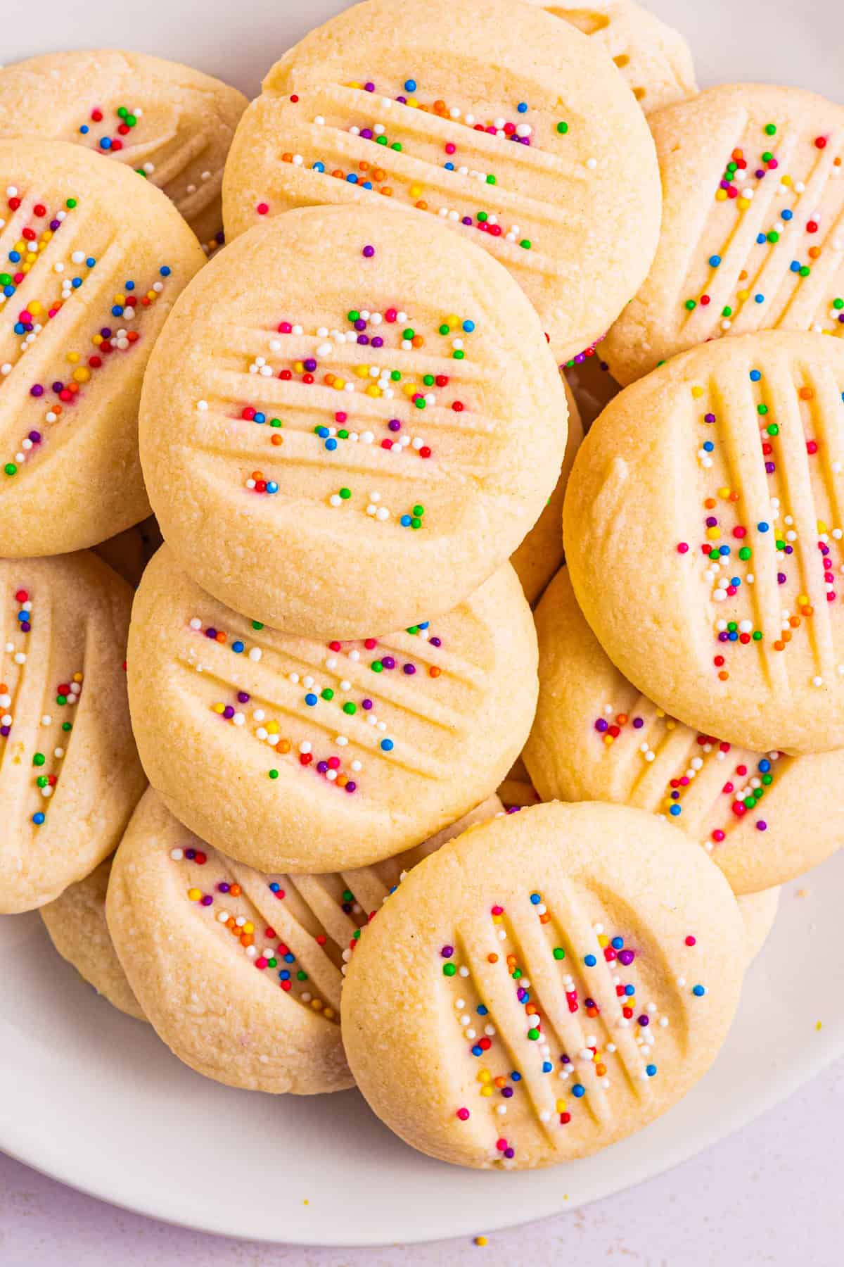 Whipped Shortbread Cookies with sprinkles - on a white plate.