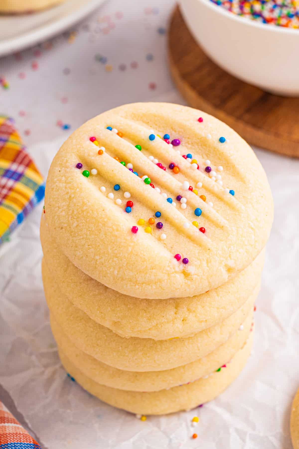 A tall stack of Whipped Shortbread Cookies with sprinkles - on a white background.