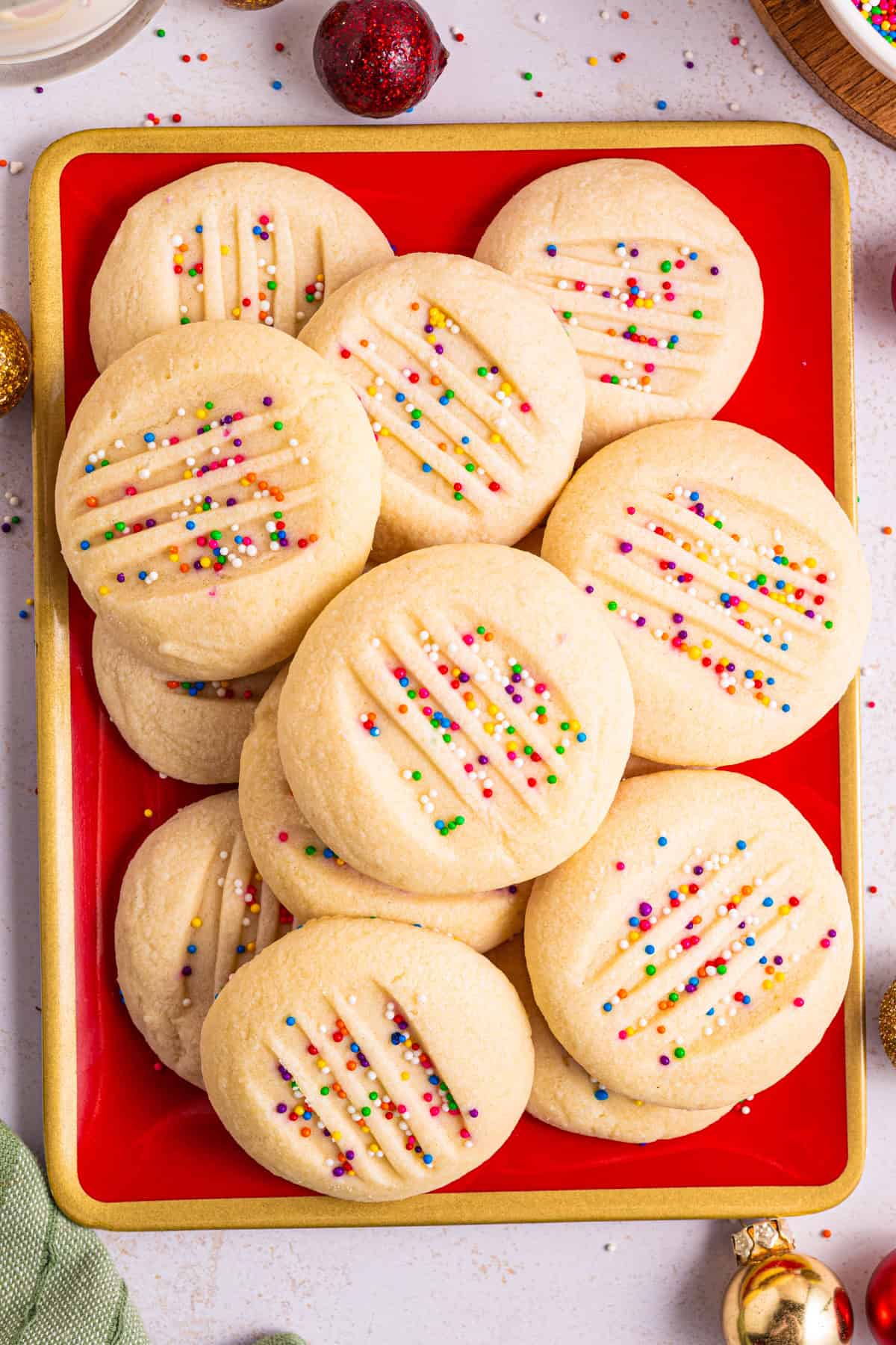 Whipped Shortbread Cookies with sprinkles - on a red platter.