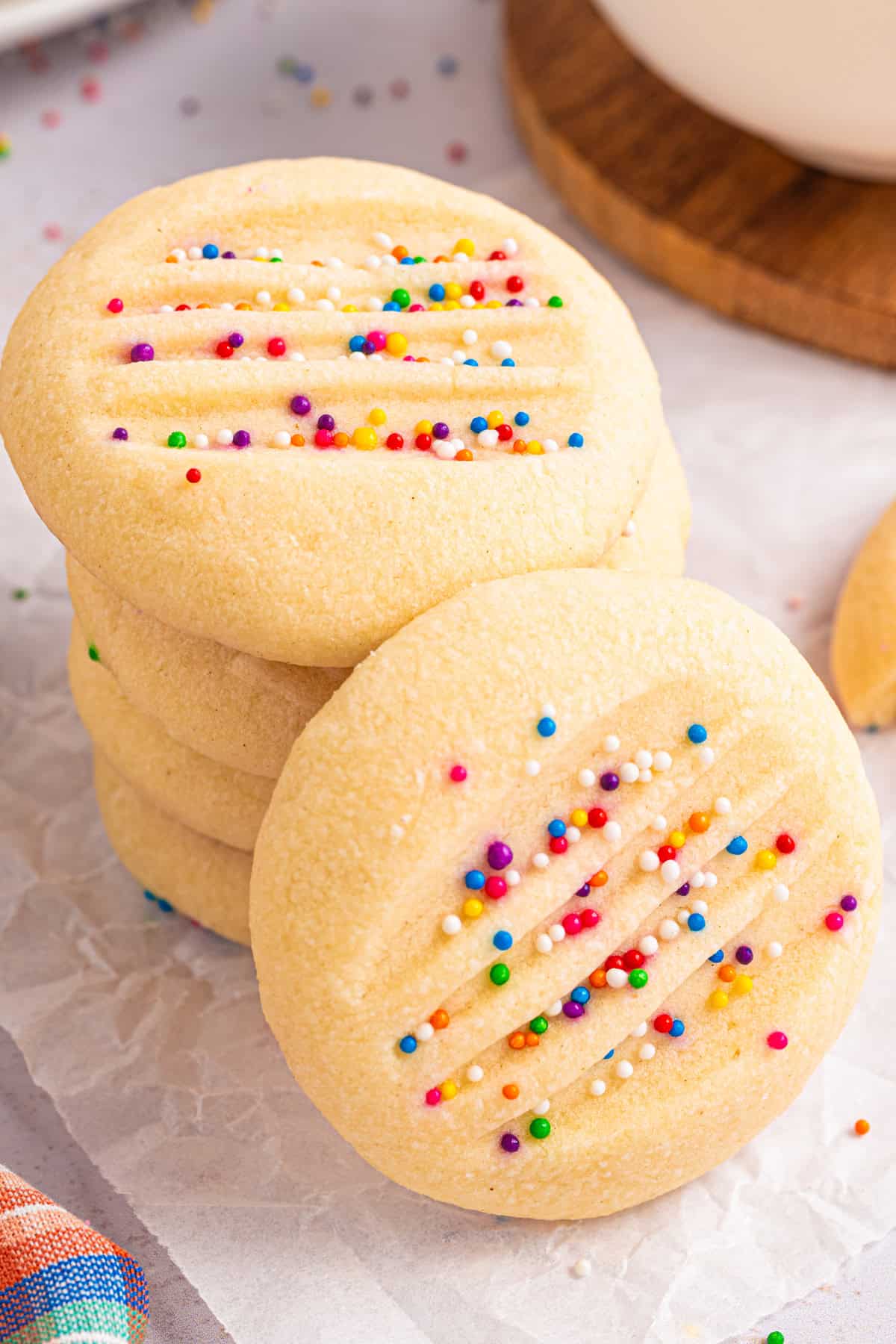 A stack of Whipped Shortbread Cookies with sprinkles - on a white background.